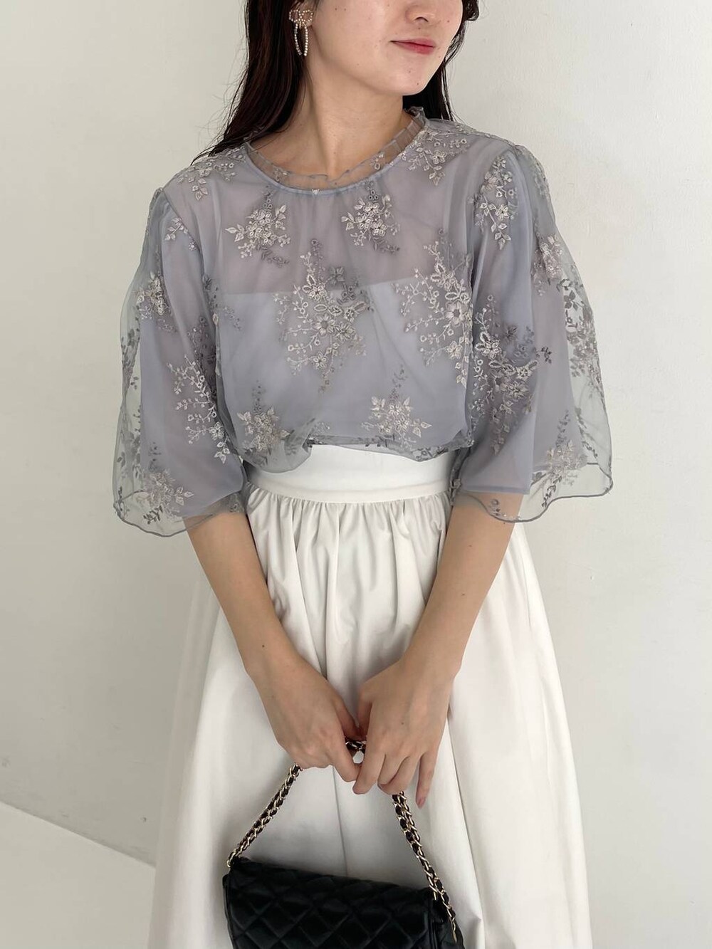 ブラック系のパンプス、ブルー系のシャツ/ブラウス、ブラック系のショルダーバッグを着用したレディースの夏コーディネートの3枚目の写真