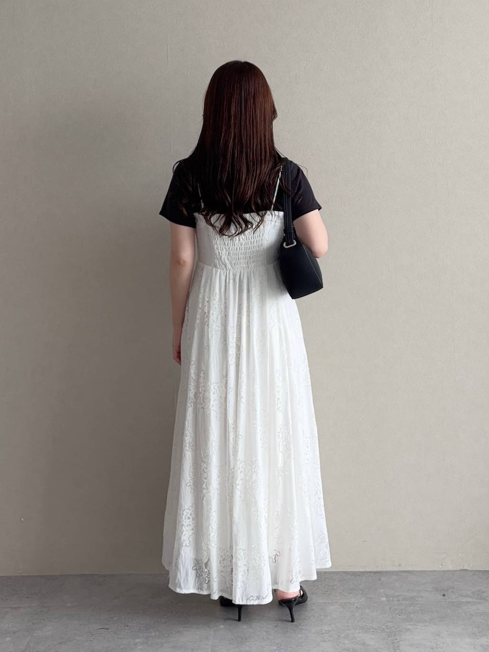 ブラック系のTシャツ/カットソー、ホワイト系のワンピース、ブラック系のサンダルを着用したレディースの夏コーディネートの2枚目の写真