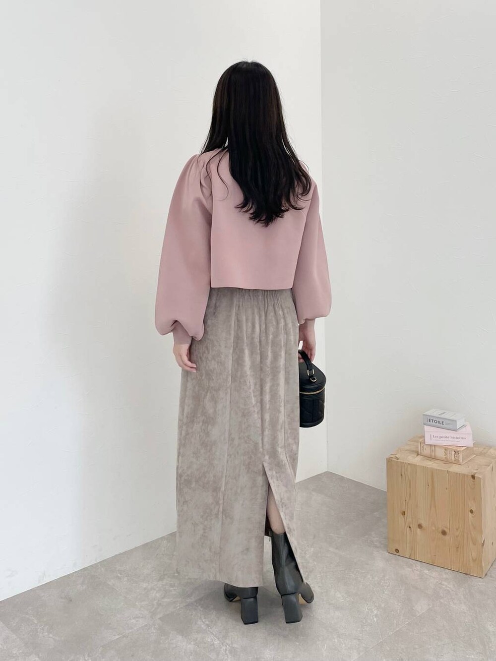 ブラウン系のスカート、ピンク系のカーディガン/ボレロ、グレー系のブーツを着用したレディースの冬コーディネートの2枚目の写真