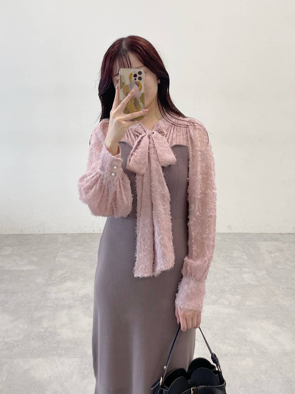 ホワイト系のノーカラーコート、ブラック系のショルダーバッグ、ブラウン系のワンピースを着用したレディースの秋コーディネートの5枚目の写真