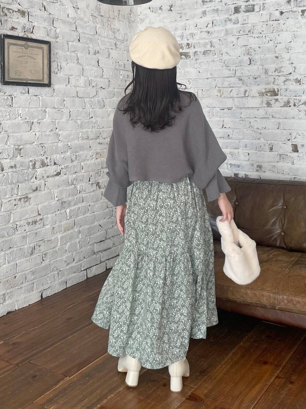 ホワイト系のブーツ、ホワイト系のハンドバッグ、グリーン系のワンピースを着用したレディースの冬コーディネートの2枚目の写真