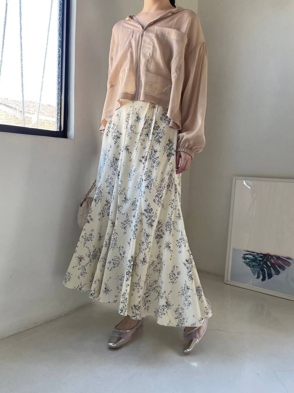 シルバー系のバレエシューズ、ホワイト系のショルダーバッグ、ベージュ系のパーカーを着用したレディースの春コーディネートの4枚目の写真