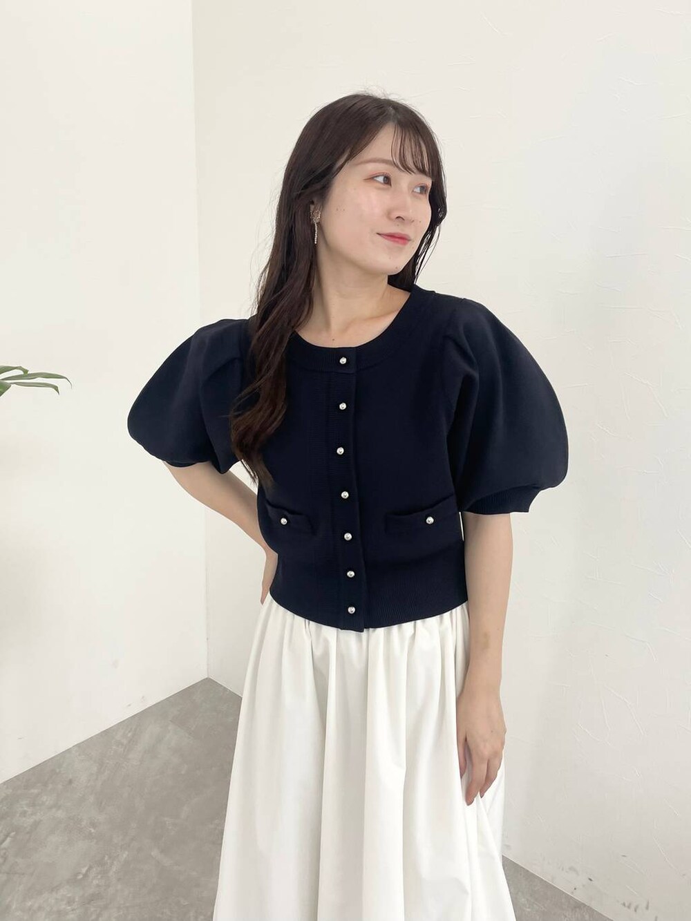 ホワイト系のスカート、ブラック系のショルダーバッグ、ホワイト系のサンダルを着用したレディースの夏コーディネートの3枚目の写真