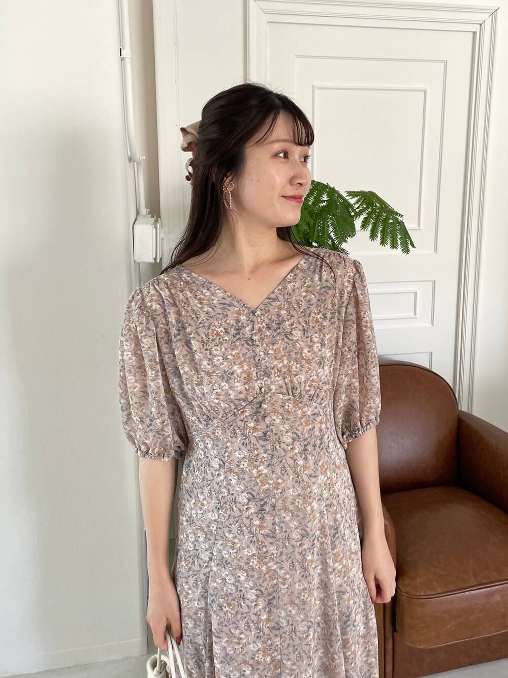 シルバー系のバレエシューズ、ホワイト系のハンドバッグ、ピンク系のワンピースを着用したレディースの夏コーディネートの3枚目の写真