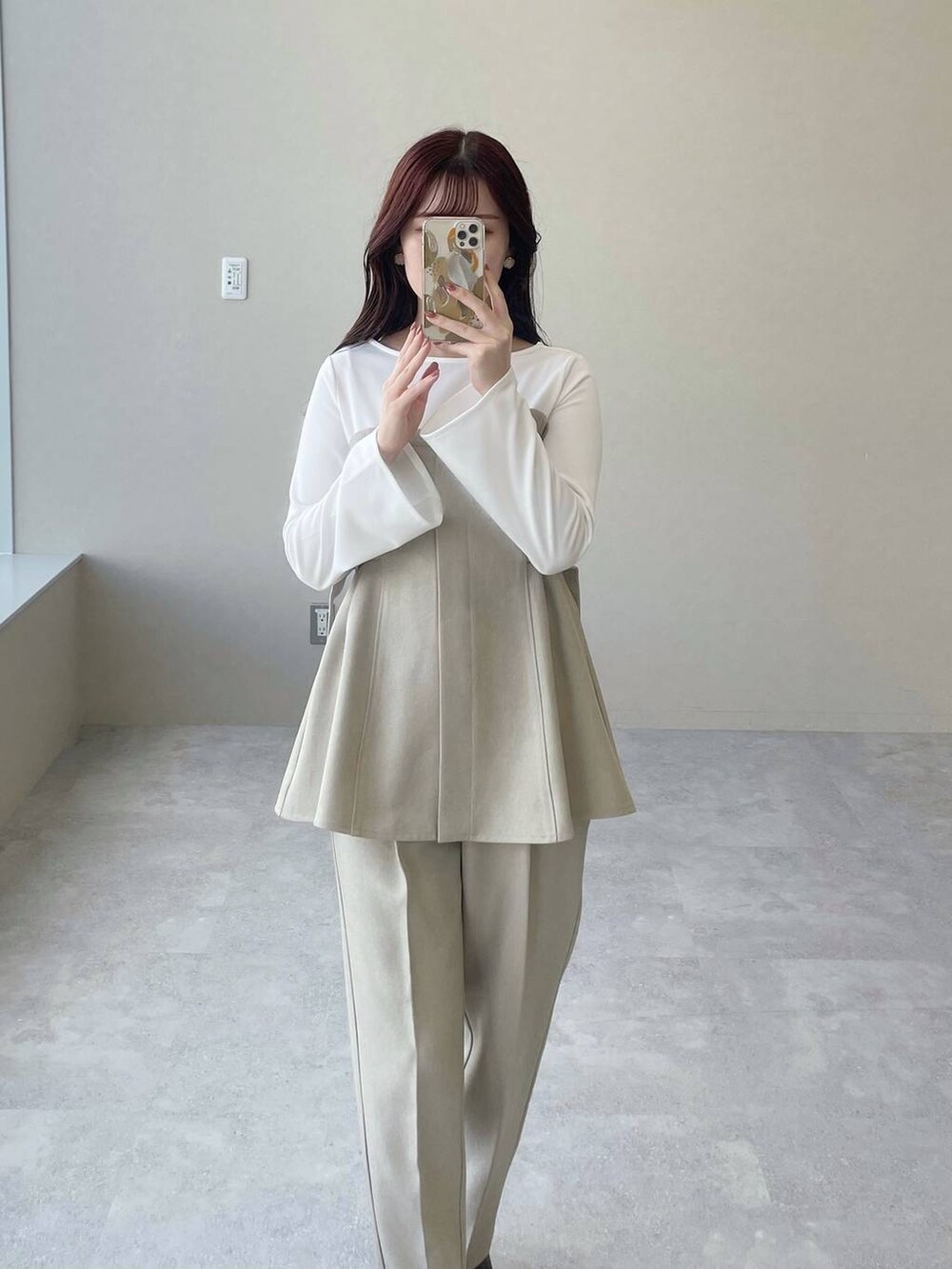 ブラウン系のブーツ、ベージュ系のTシャツ/カットソー、ベージュ系のスラックスを着用したレディースの冬コーディネートの2枚目の写真