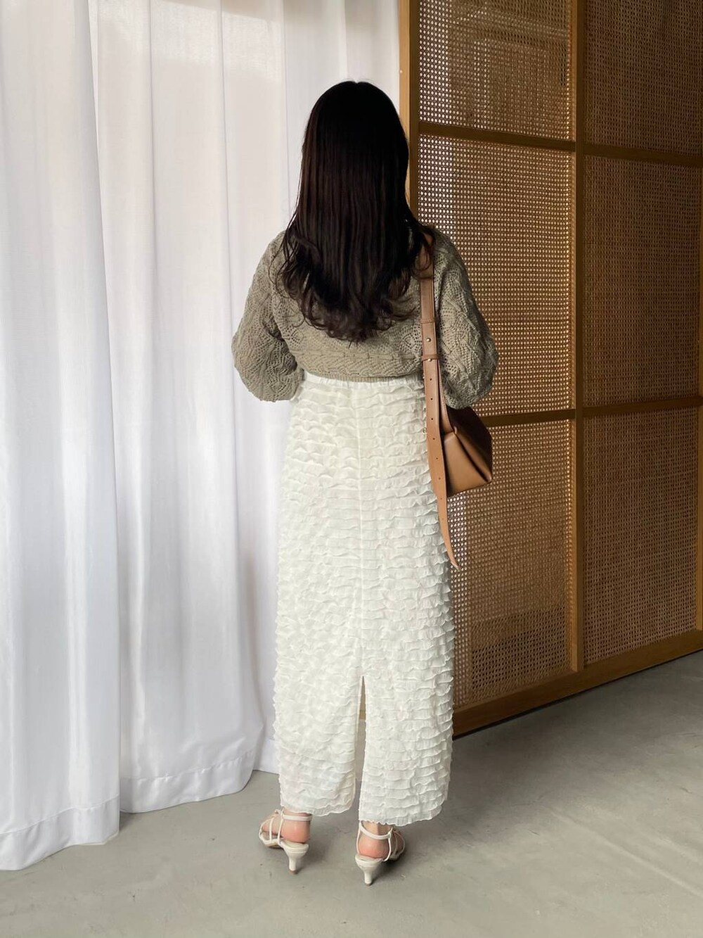 グレー系のワンピース、ホワイト系のスカート、ホワイト系のタンクトップを着用したレディースの春コーディネートの2枚目の写真