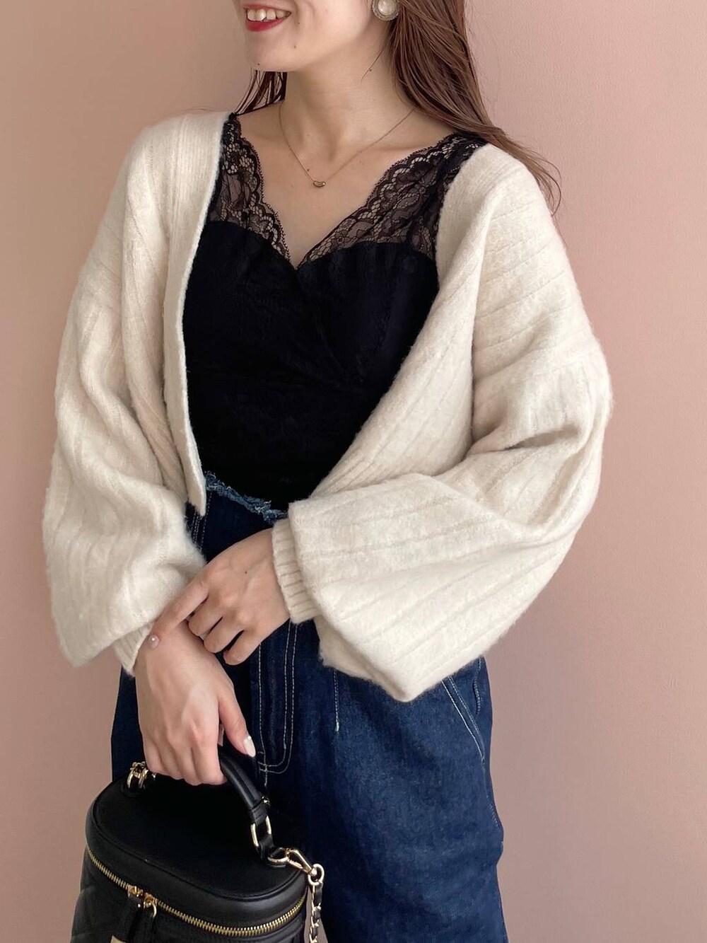 ブルー系のデニムパンツ、ホワイト系のパンプス、ブラック系のショルダーバッグを着用したレディースの秋コーディネートの3枚目の写真