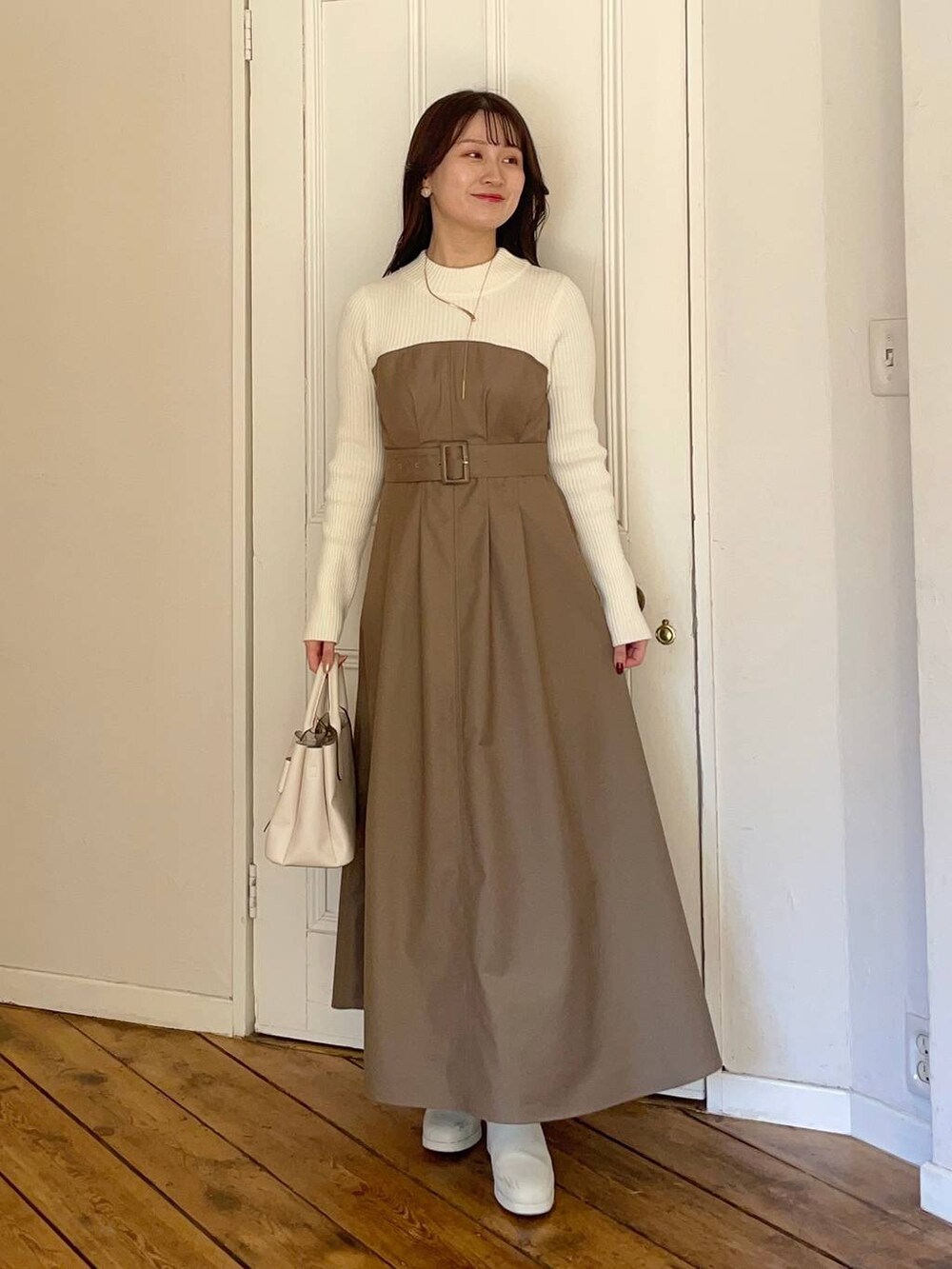 ホワイト系のブーツ、ホワイト系のショルダーバッグ、ホワイト系のテーラードジャケットを着用したレディースの冬コーディネートの3枚目の写真