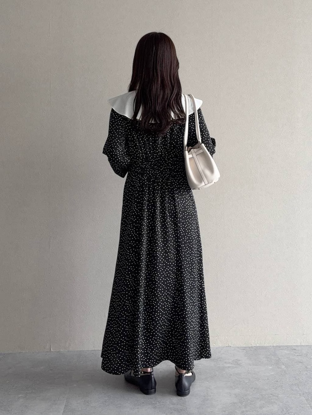 ブラック系のパンプス、ブラック系のワンピースを着用したレディースの春コーディネートの2枚目の写真