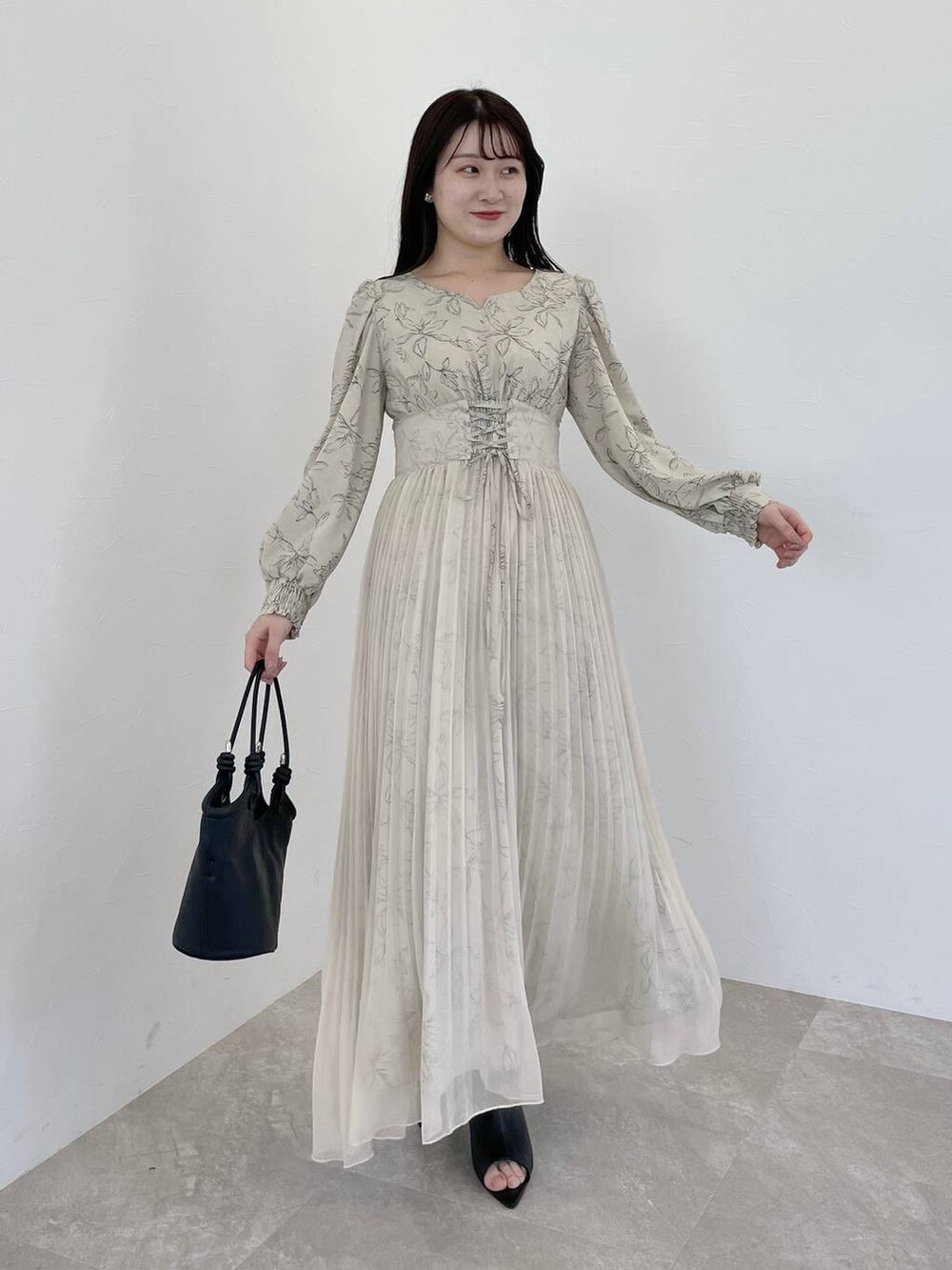 ベージュ系のワンピース、ブラック系のハンドバッグ、ブラック系のブーツを着用したレディースの冬コーディネートの4枚目の写真