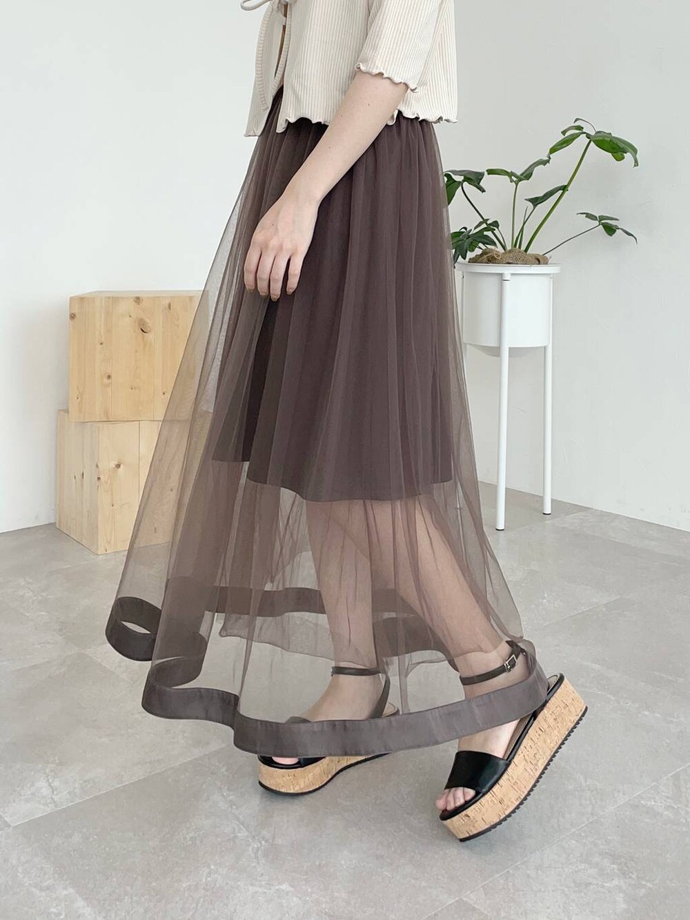 ホワイト系のカーディガン/ボレロ、ブラック系のサンダル、ブラック系のボストンバッグを着用したレディースの夏コーディネートの3枚目の写真