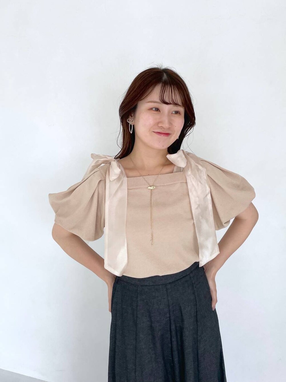 ブラック系のスカート、ホワイト系のショルダーバッグ、ホワイト系のサンダルを着用したレディースの夏コーディネートの3枚目の写真