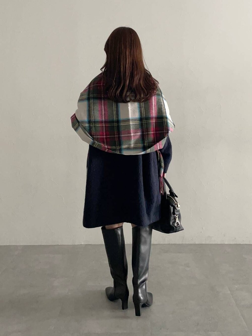 ブラック系のボストンバッグ、ホワイト系のニット/セーター、ブルー系のチェスターコートを着用したレディースの秋コーディネートの2枚目の写真