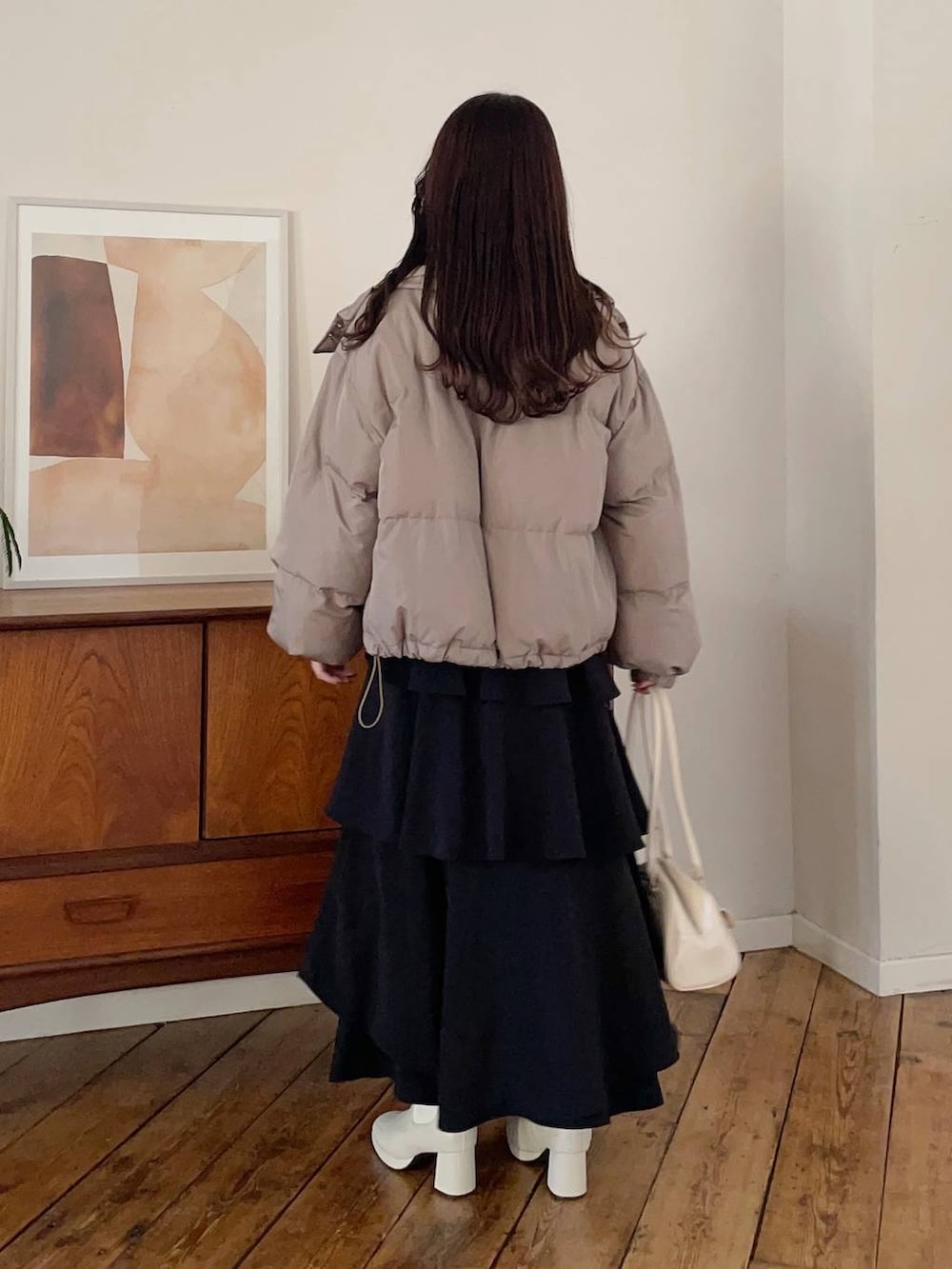 ホワイト系のブーツ、ブラック系のスカート、ブラウン系のブルゾンを着用したレディースの冬コーディネートの2枚目の写真