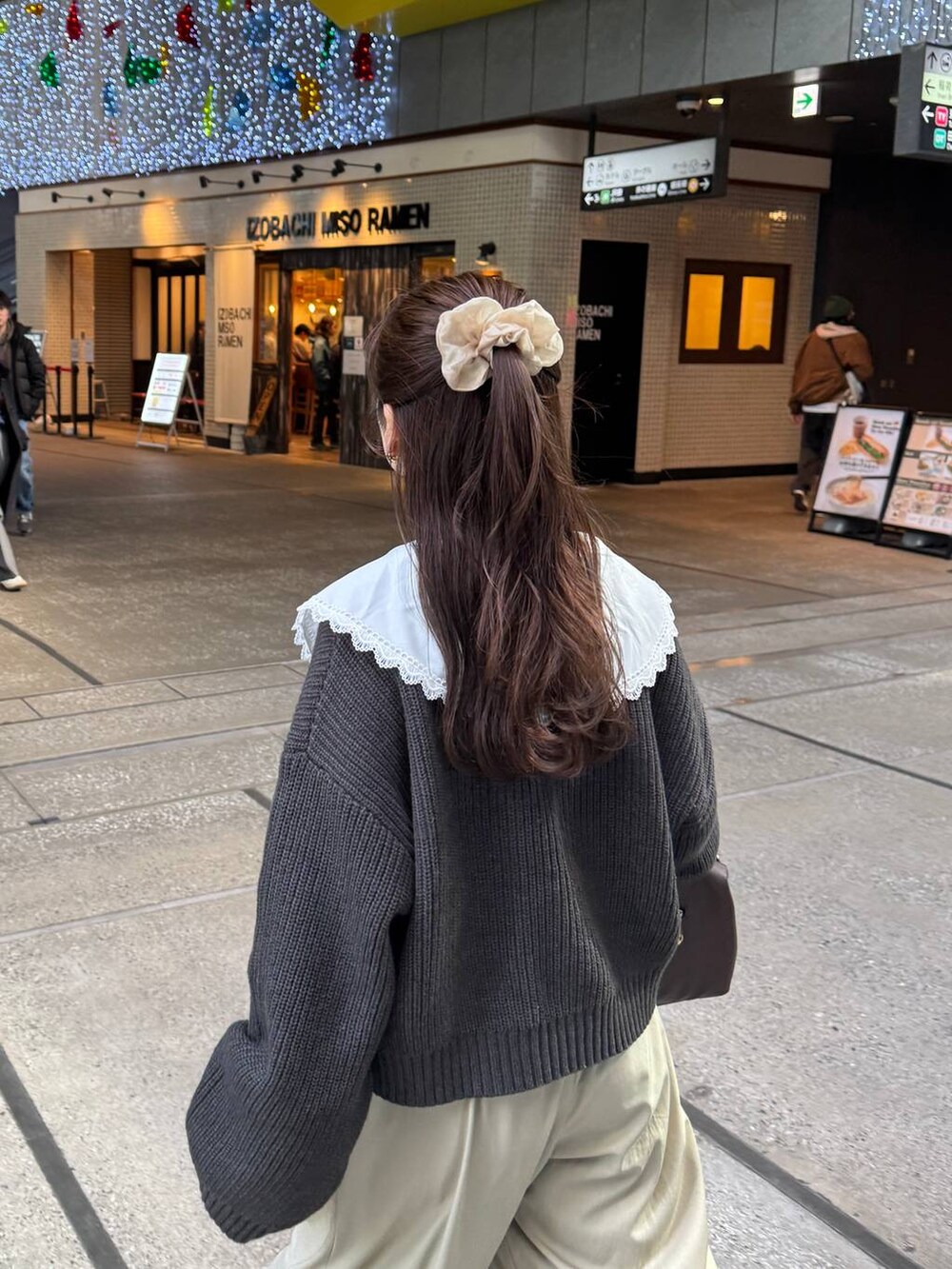 ブラウン系のボストンバッグ、グレー系のカーディガン/ボレロを着用したレディースの冬コーディネートの3枚目の写真