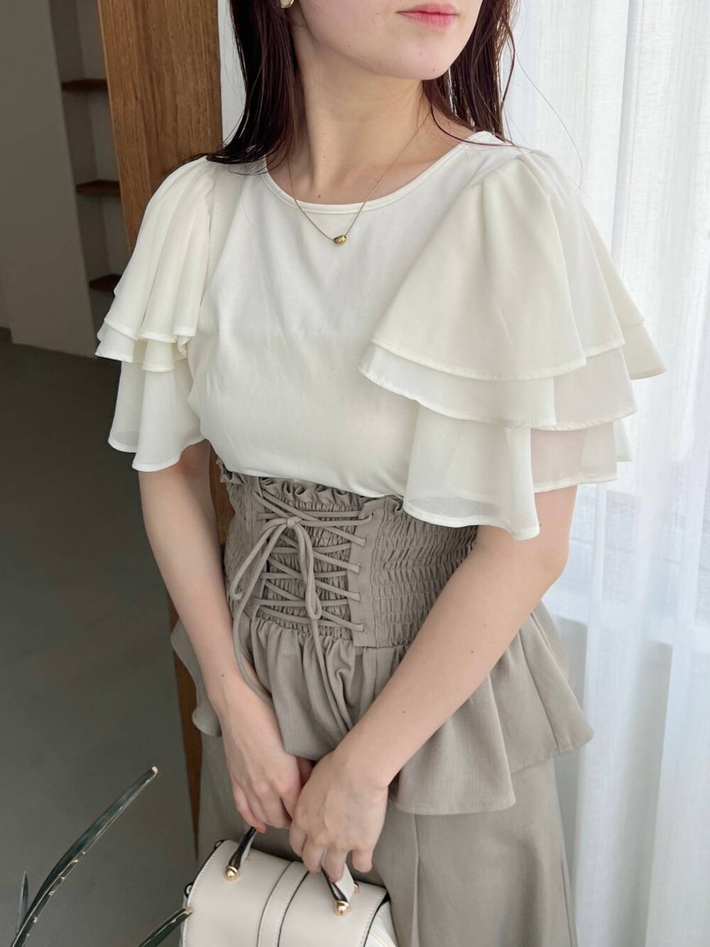 ゴールド系のパンプス、ホワイト系のショルダーバッグ、ホワイト系のTシャツ/カットソーを着用したレディースの春コーディネートの6枚目の写真