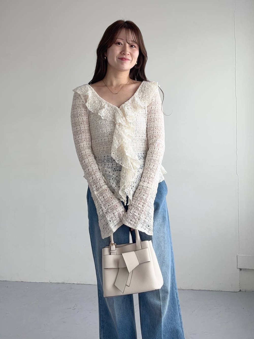 ホワイト系のシャツ/ブラウス、ブルー系のデニムパンツ、ホワイト系のショルダーバッグを着用したレディースの秋コーディネートの3枚目の写真
