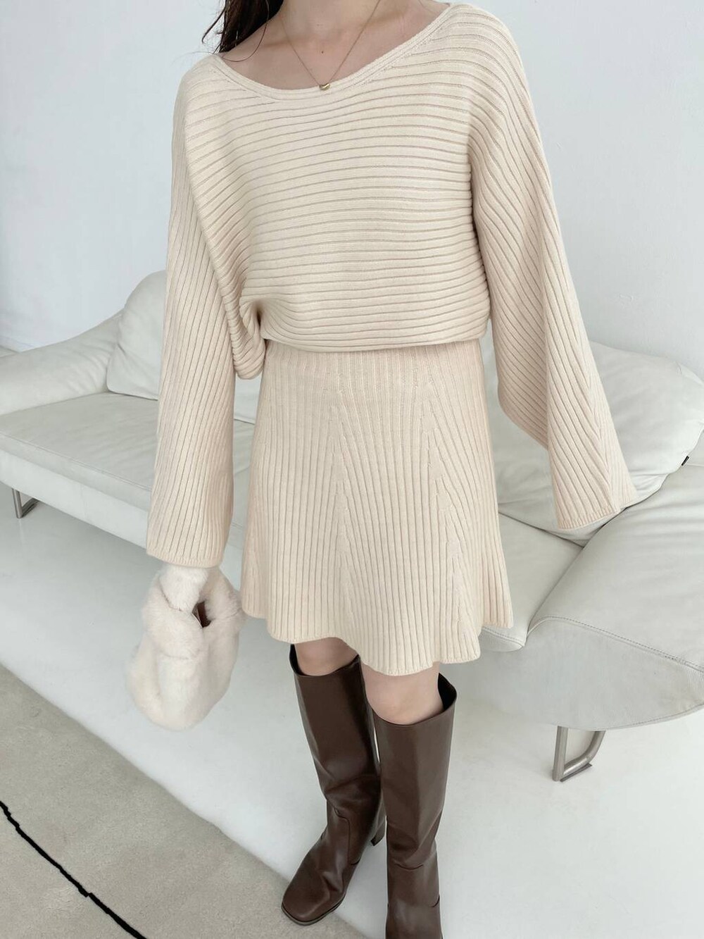 ブラウン系のブーツ、ホワイト系のハンドバッグ、ホワイト系のワンピースを着用したレディースの秋コーディネートの6枚目の写真