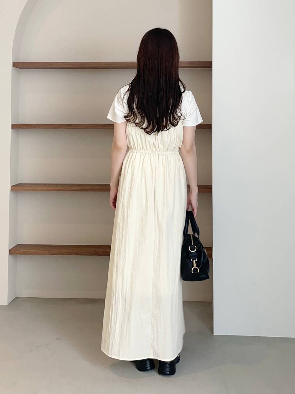 ベージュ系のサンダル、ホワイト系のTシャツ/カットソー、ブラック系のボストンバッグを着用したレディースの夏コーディネートの2枚目の写真