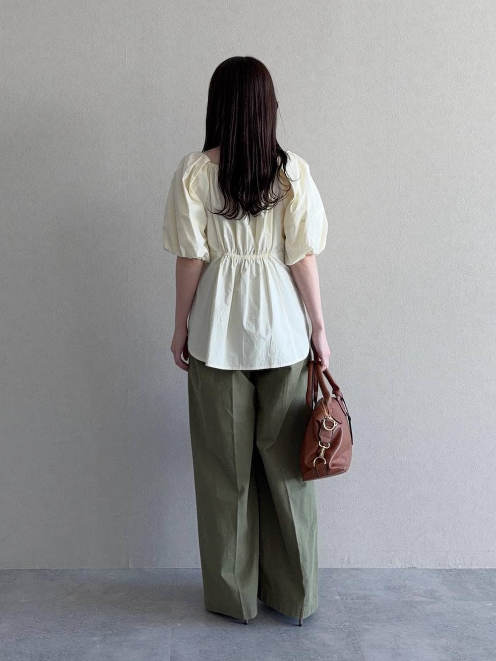 ブラウン系のボストンバッグ、ブラウン系のサンダル、ホワイト系のシャツ/ブラウスを着用したレディースの春コーディネートの2枚目の写真