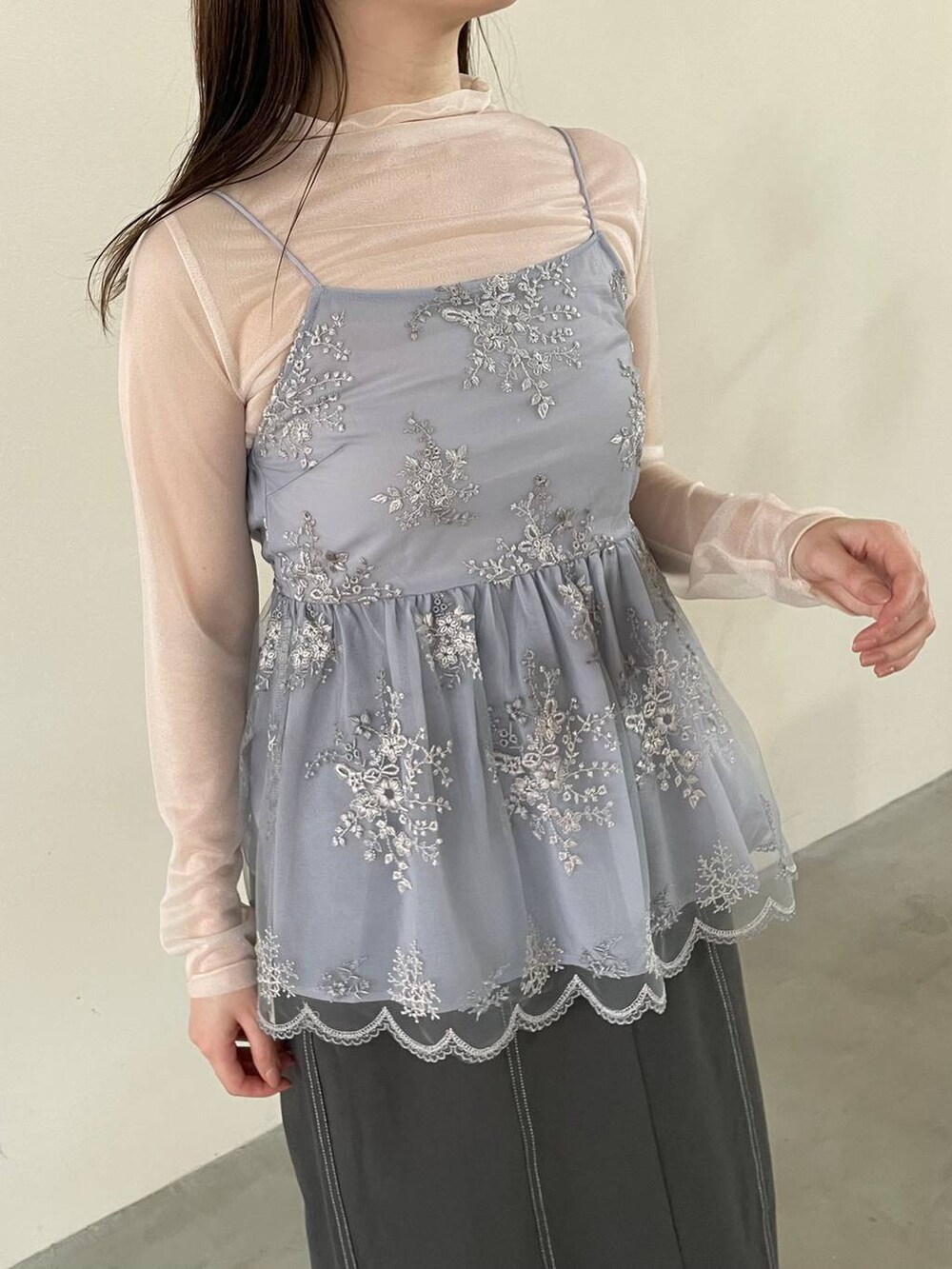 グレー系のスカート、ブルー系のその他トップス、ホワイト系のパンプスを着用したレディースの春コーディネートの3枚目の写真