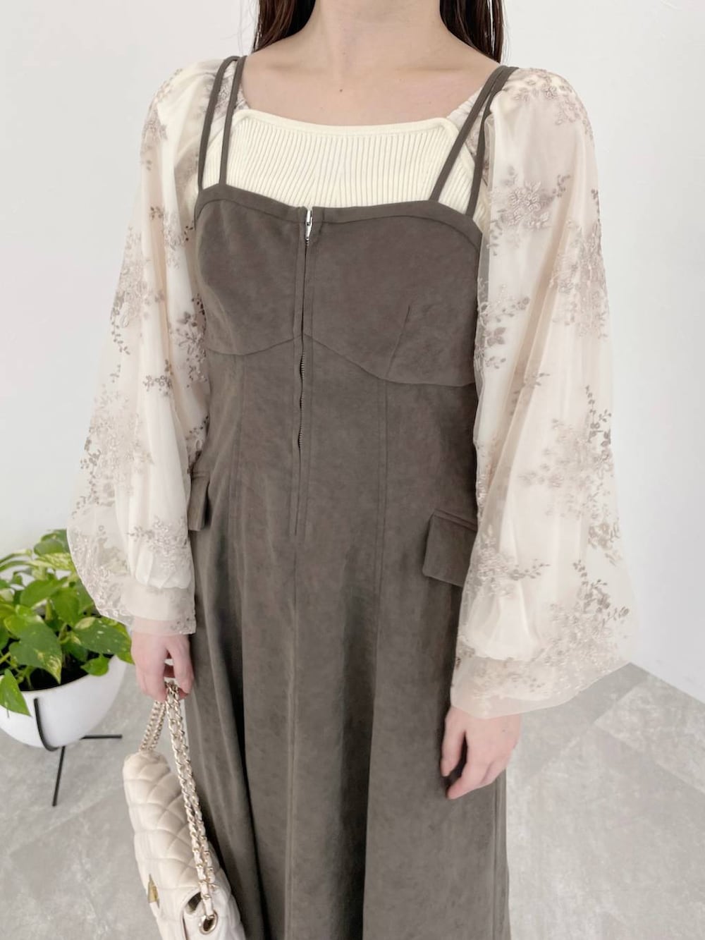 グレー系のワンピース、ホワイト系のショルダーバッグ、ホワイト系のニット/セーターを着用したレディースの冬コーディネートの5枚目の写真