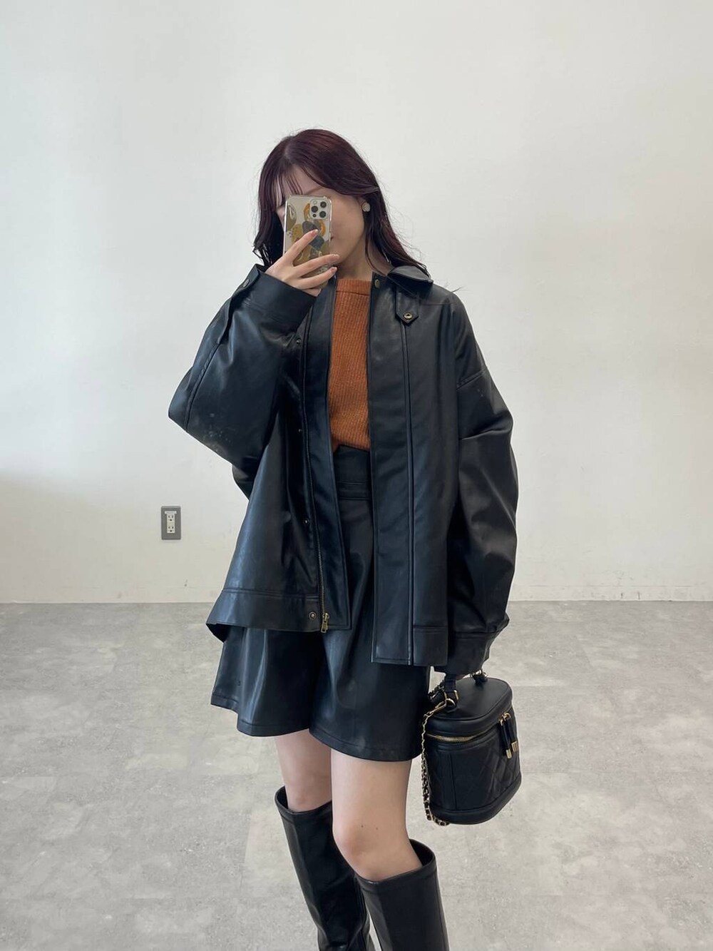 ブラック系のブーツ、ブラック系のその他パンツ、オレンジ系のニット/セーターを着用したレディースの秋コーディネートの6枚目の写真