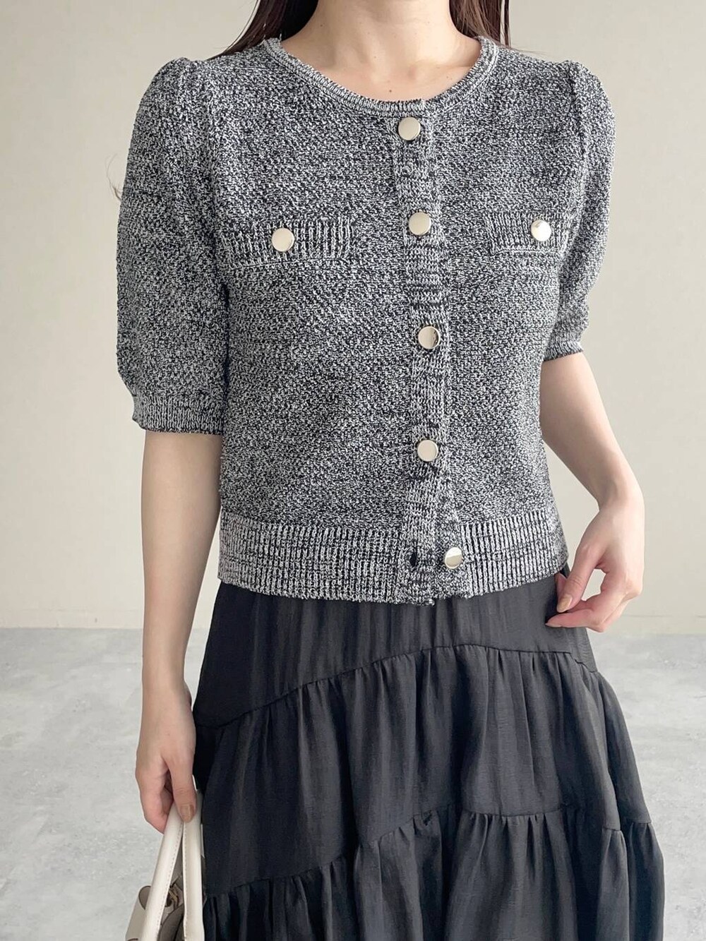 ホワイト系のショルダーバッグ、ブラック系のパンプス、ブラック系のカーディガン/ボレロを着用したレディースの夏コーディネートの3枚目の写真