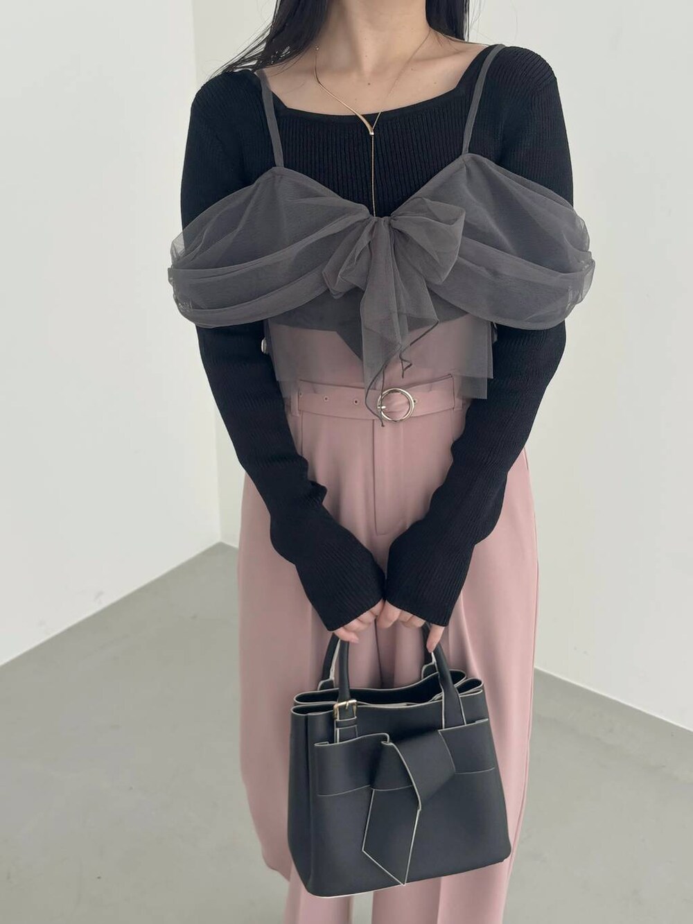 ホワイト系のブーツ、ブラック系のショルダーバッグ、ピンク系のその他パンツを着用したレディースの冬コーディネートの3枚目の写真