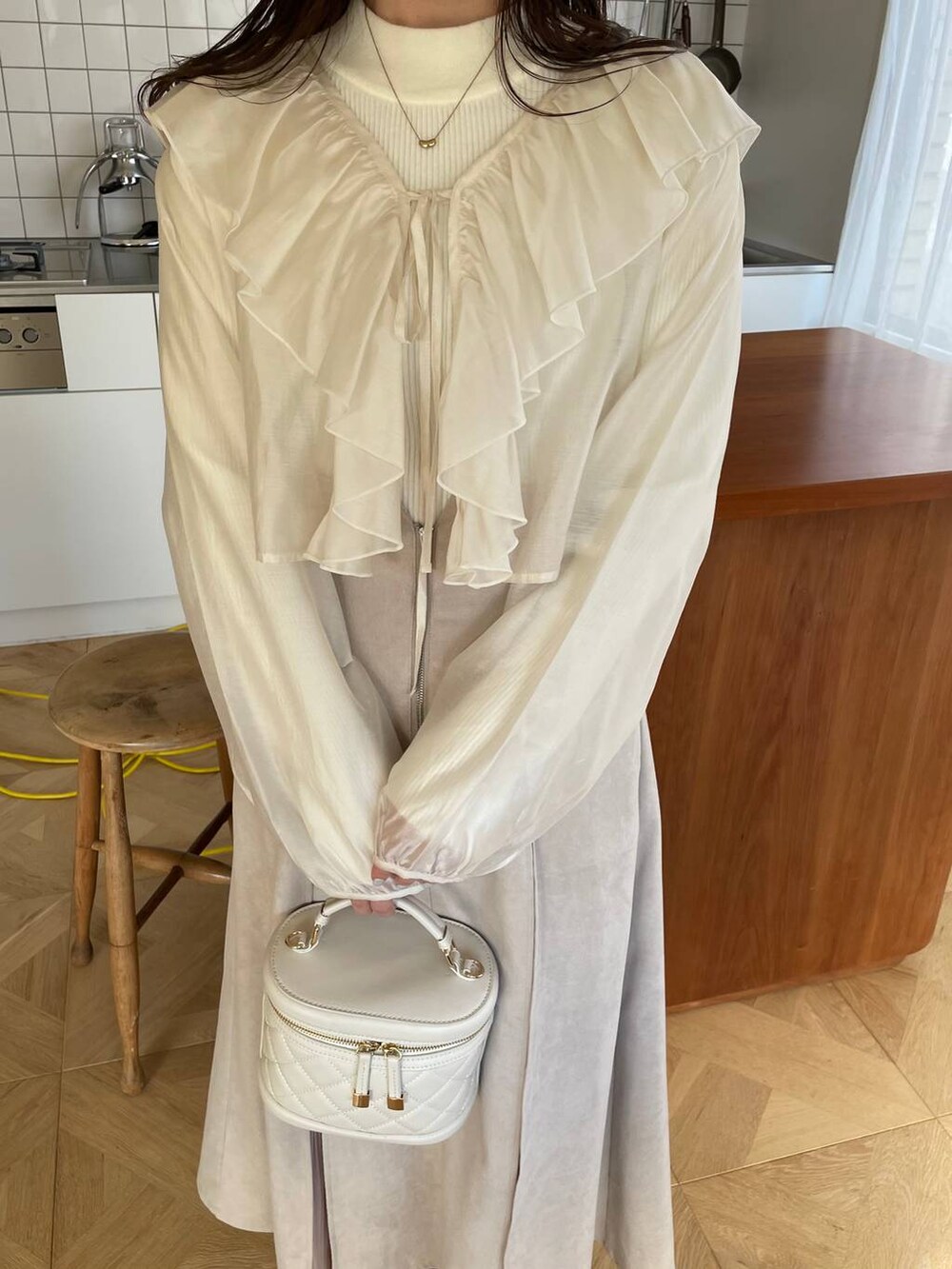 ホワイト系のショルダーバッグ、ブラウン系のブーツ、ホワイト系のシャツ/ブラウスを着用したレディースの冬コーディネートの3枚目の写真