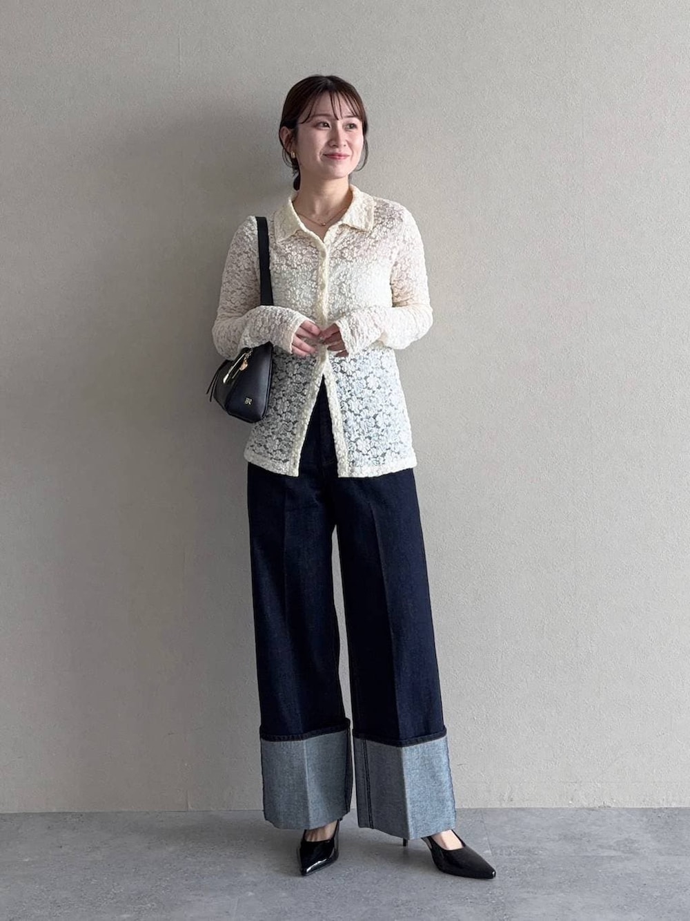 ベージュ系のトレンチコート、ブラック系のサンダル、ブルー系のデニムパンツを着用したレディースの冬コーディネートの4枚目の写真