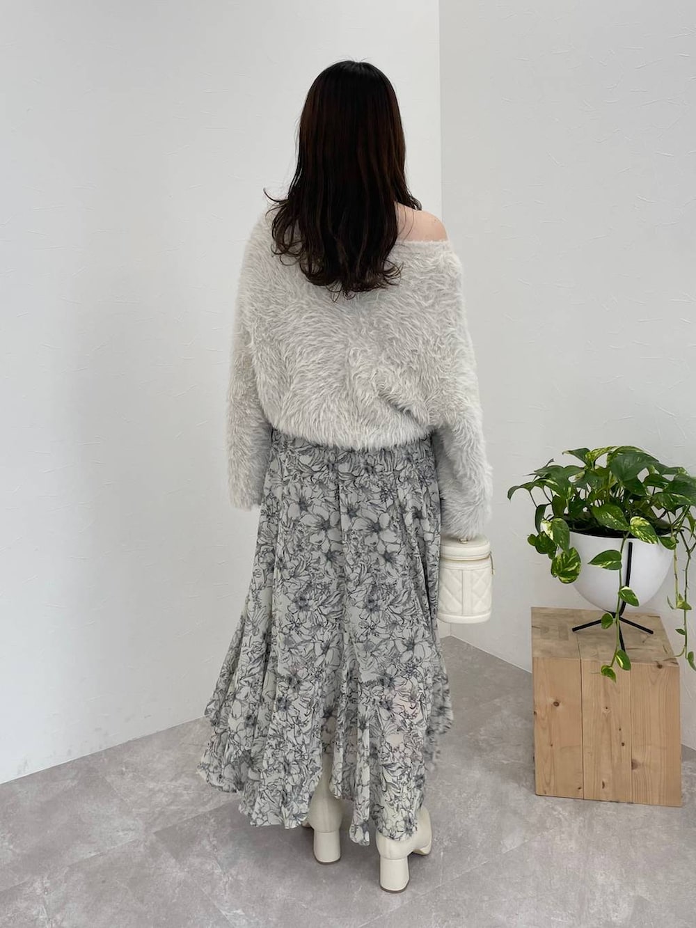 ホワイト系のブーツ、ベージュ系のスカート、ホワイト系のショルダーバッグを着用したレディースの冬コーディネートの5枚目の写真