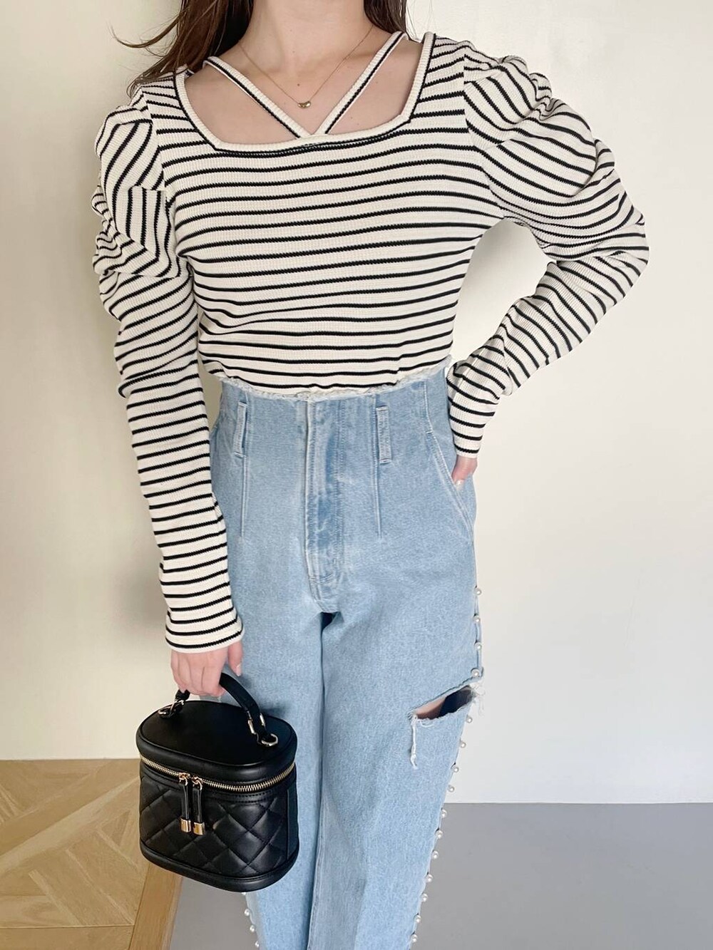 ブラック系のショルダーバッグ、ブルー系のデニムパンツ、ホワイト系のTシャツ/カットソーを着用したレディースの冬コーディネートの3枚目の写真