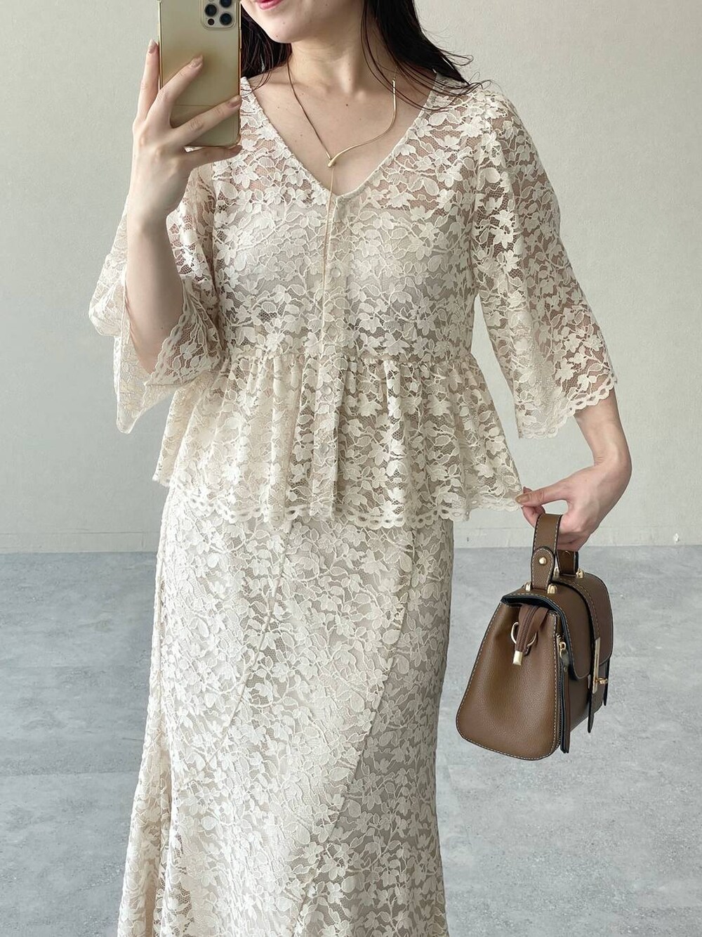 ゴールド系のパンプス、ブラウン系のショルダーバッグ、ベージュ系のシャツ/ブラウスを着用したレディースの夏コーディネートの3枚目の写真