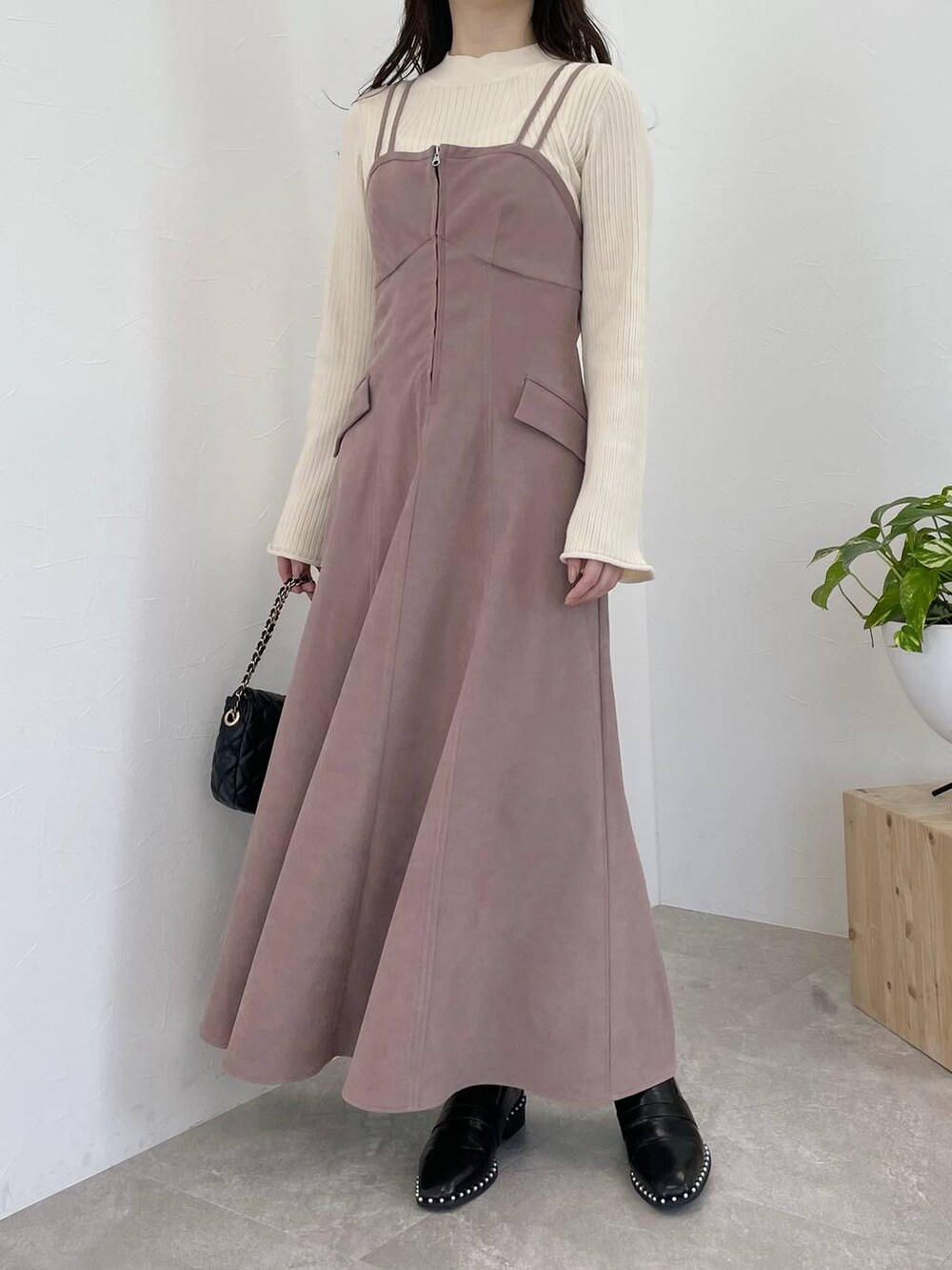 ピンク系のワンピース、ブラック系のショルダーバッグ、ホワイト系のニット/セーターを着用したレディースの冬コーディネートの4枚目の写真