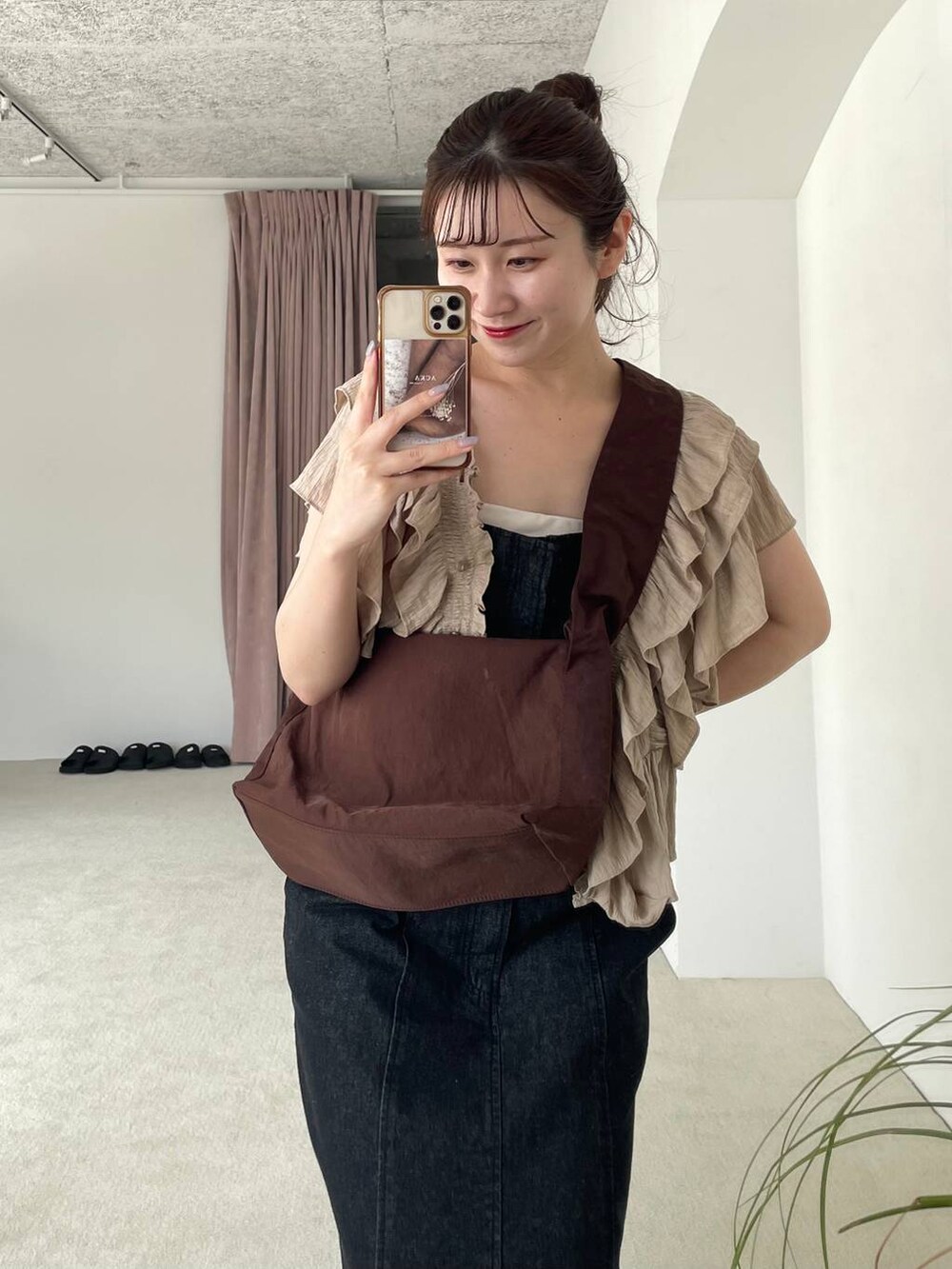 ベージュ系のシャツ/ブラウス、ホワイト系のサンダル、ブラック系のジャンパースカートを着用したレディースの夏コーディネートの4枚目の写真