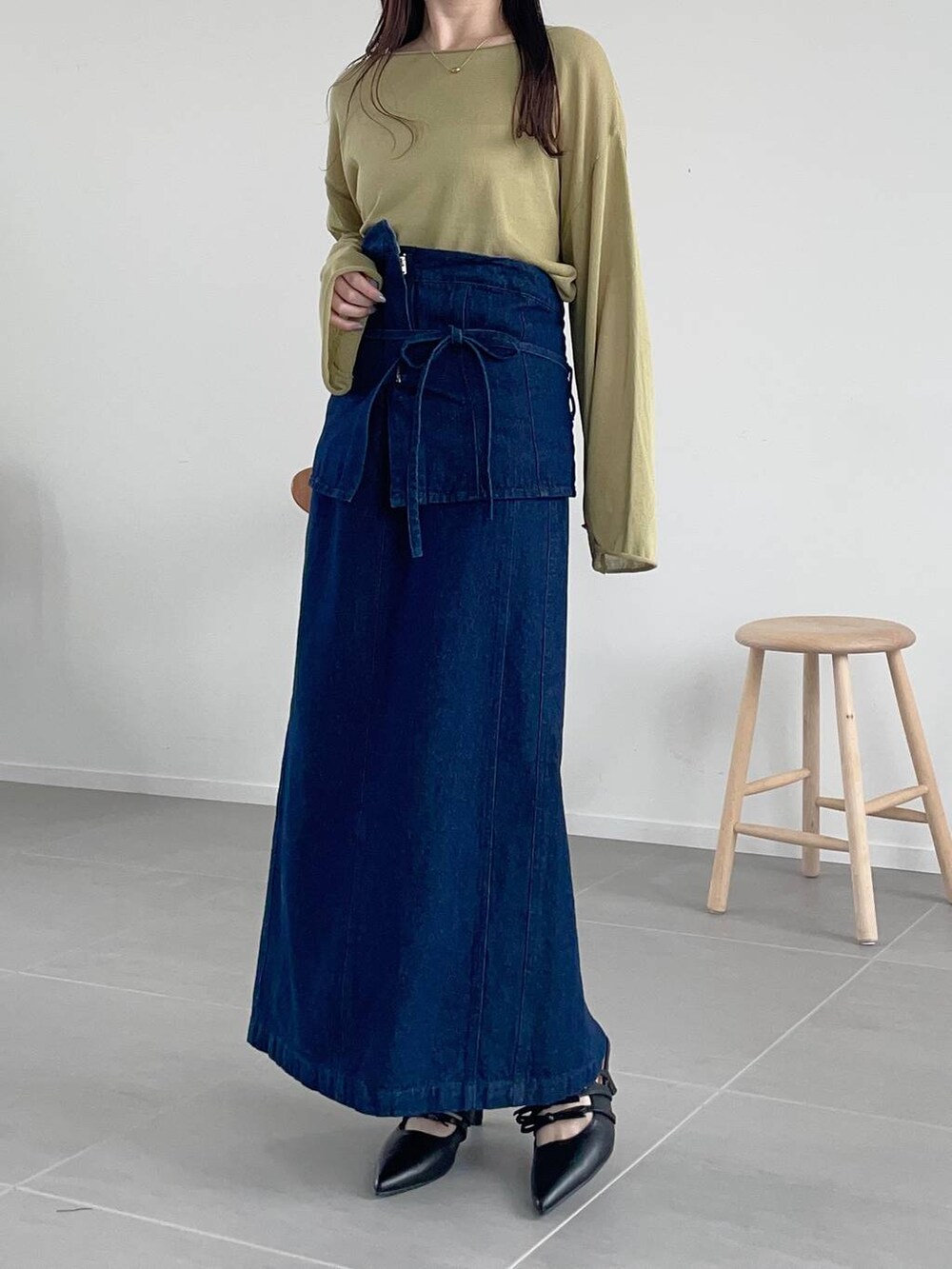 グリーン系のニット/セーター、ブルー系のスカート、ブラック系のショルダーバッグを着用したレディースの春コーディネートの3枚目の写真