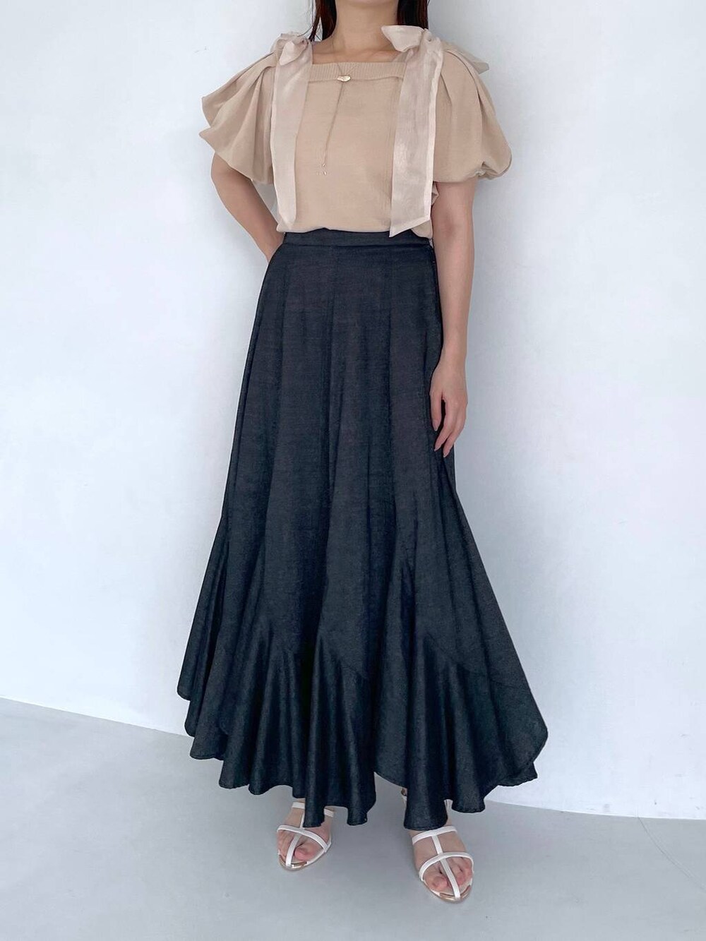 ブラック系のスカート、ホワイト系のショルダーバッグ、ホワイト系のサンダルを着用したレディースの夏コーディネートの4枚目の写真