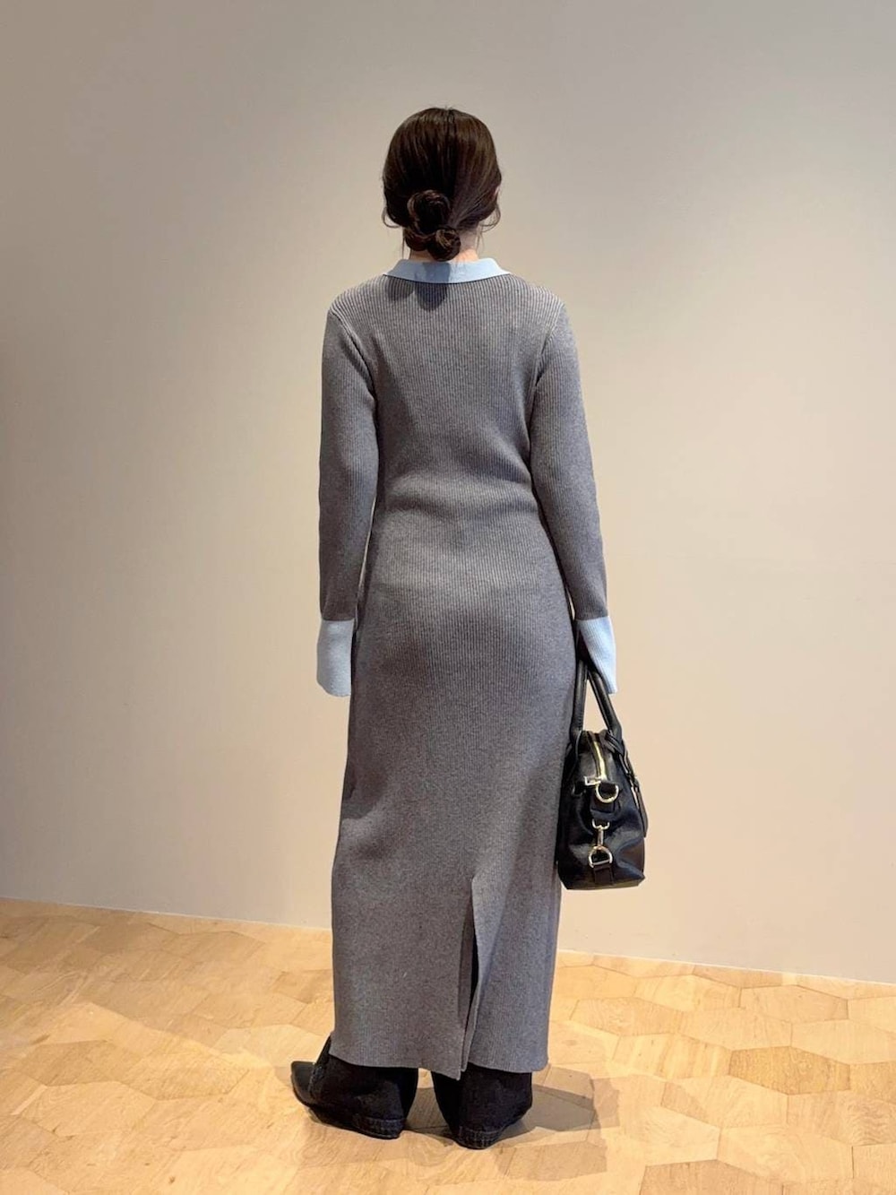 ブラック系のボストンバッグ、グレー系のワンピース、ブラック系のデニムパンツを着用したレディースの冬コーディネートの4枚目の写真