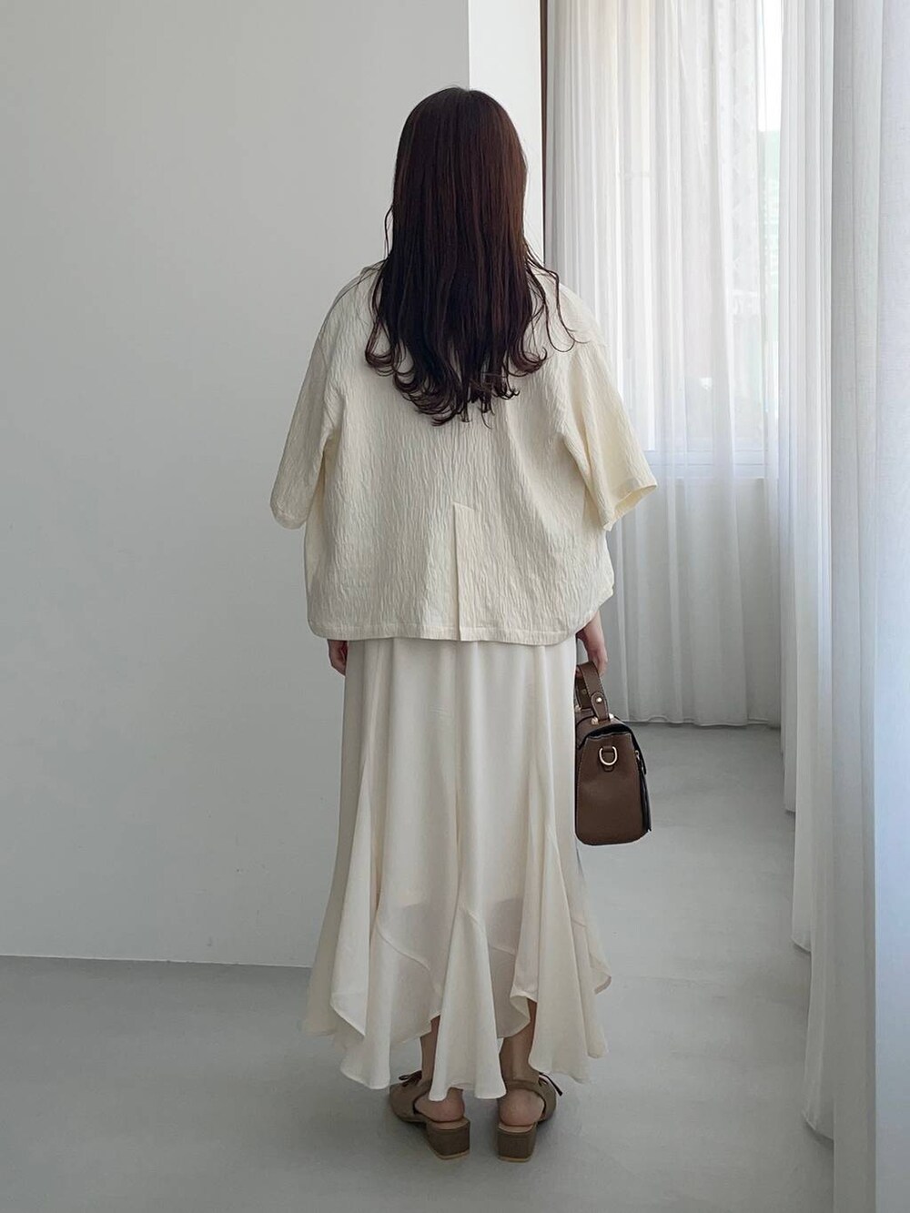 ブラウン系のサンダル、ホワイト系のテーラードジャケット、ピンク系のシャツ/ブラウスを着用したレディースの春コーディネートの2枚目の写真