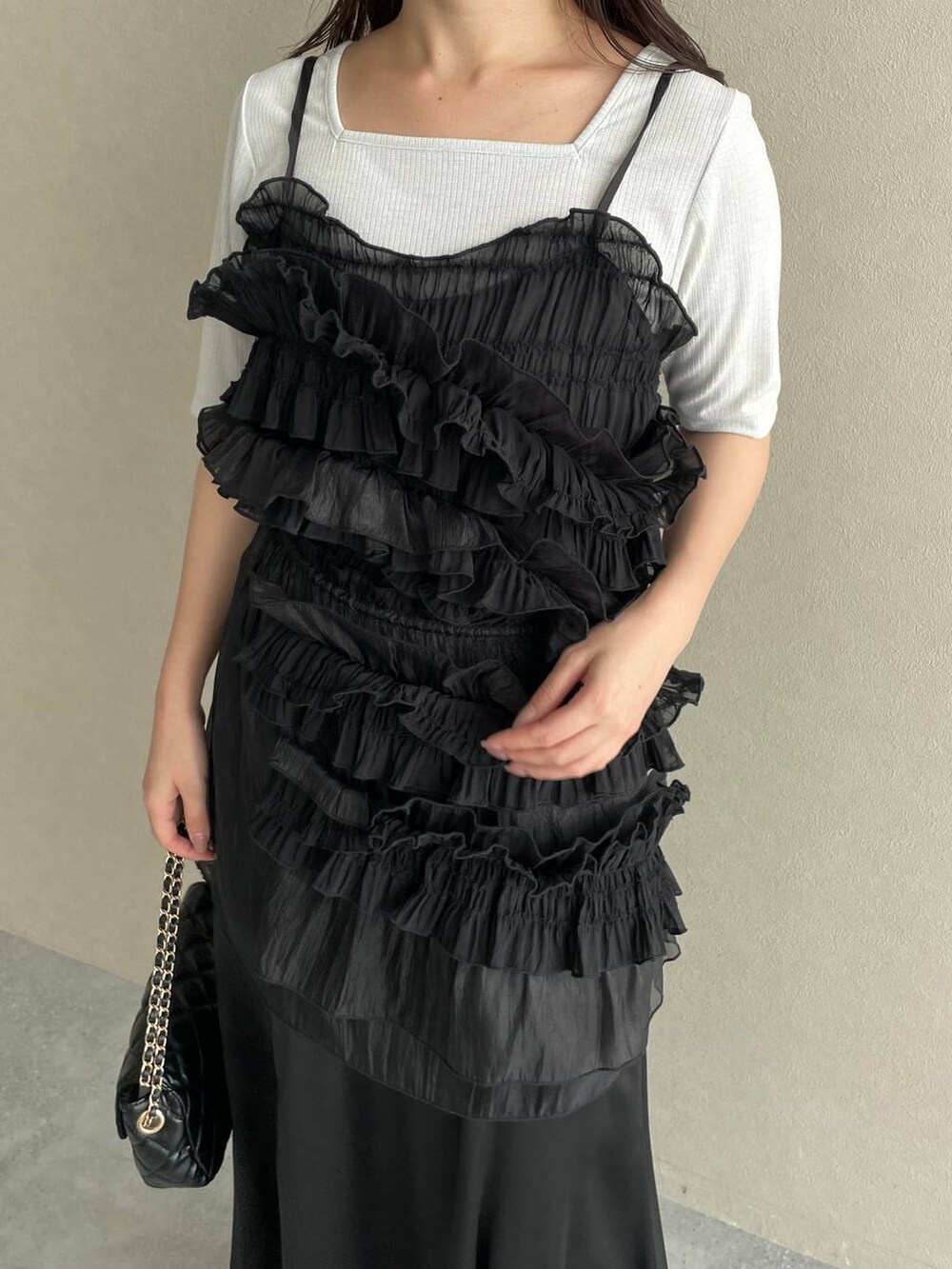 ブラック系のスカート、ブラック系のショルダーバッグ、ホワイト系のサンダルを着用したレディースの夏コーディネートの3枚目の写真