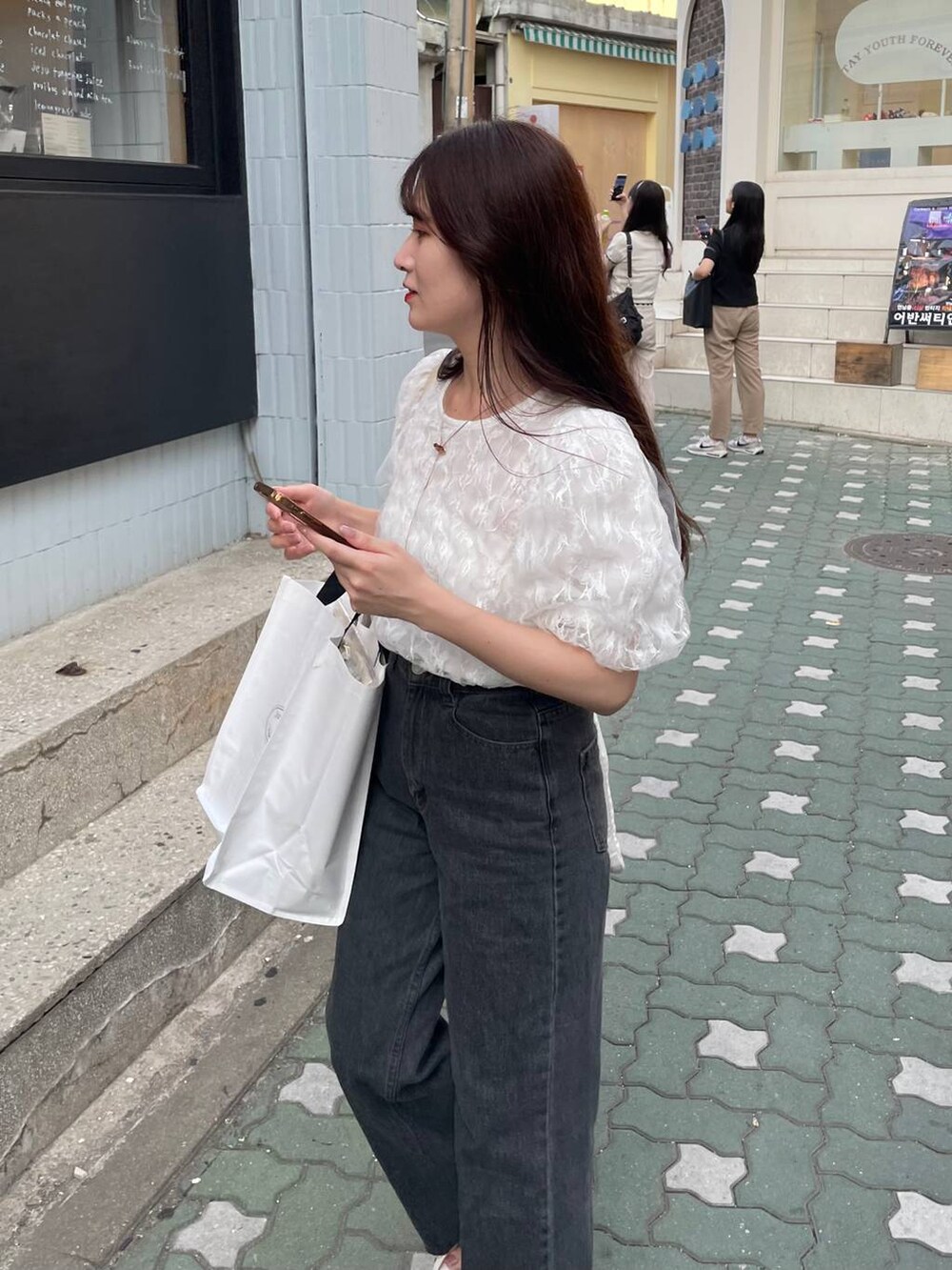 ホワイト系のシャツ/ブラウス、ホワイト系のサンダル、ブラック系のデニムパンツを着用したレディースの夏コーディネートの2枚目の写真