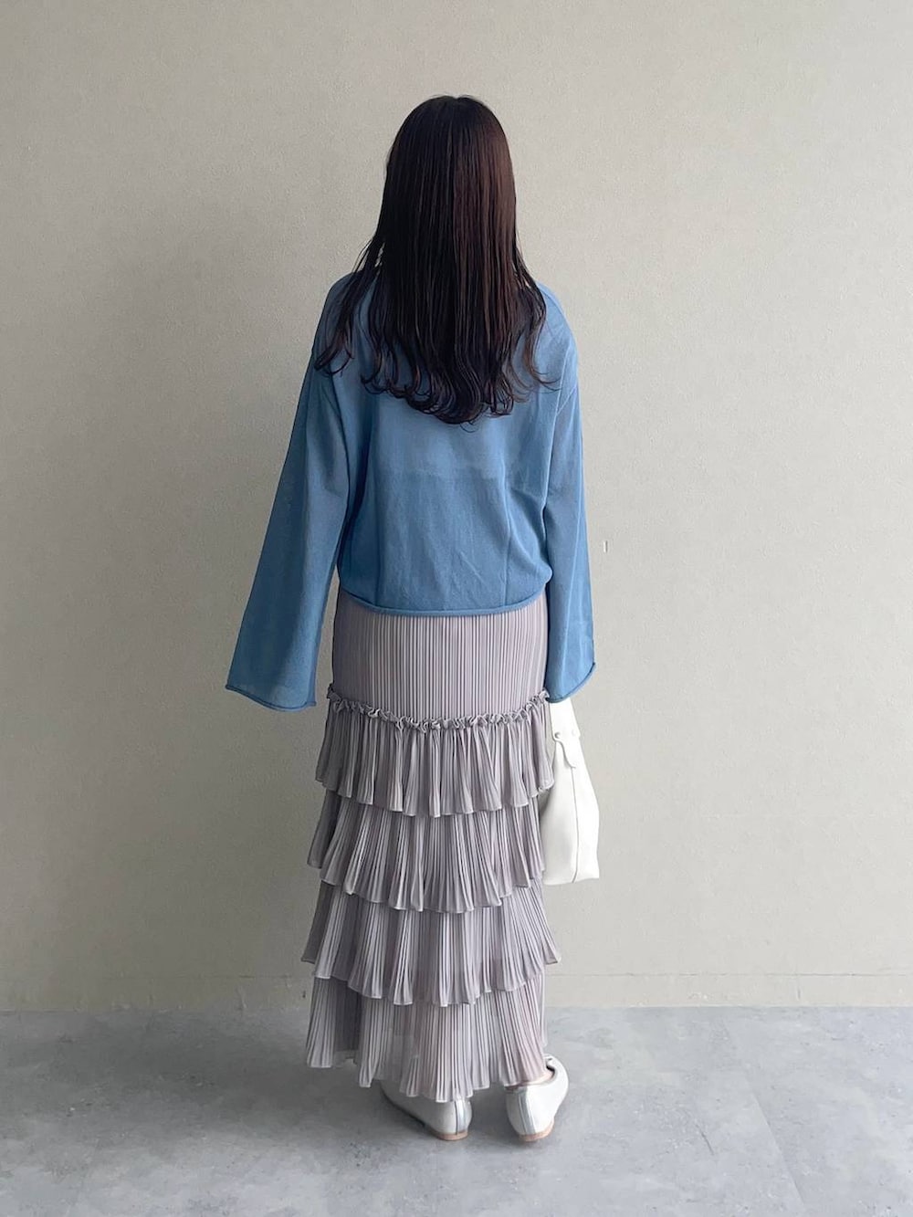 ブルー系のニット/セーター、シルバー系のバレエシューズ、グレー系のスカートを着用したレディースの春コーディネートの2枚目の写真