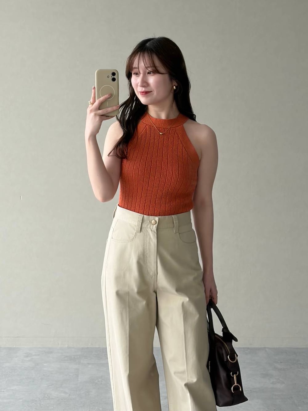 ホワイト系のパーカー、ブラウン系のボストンバッグ、ブラウン系のサンダルを着用したレディースの春コーディネートの6枚目の写真