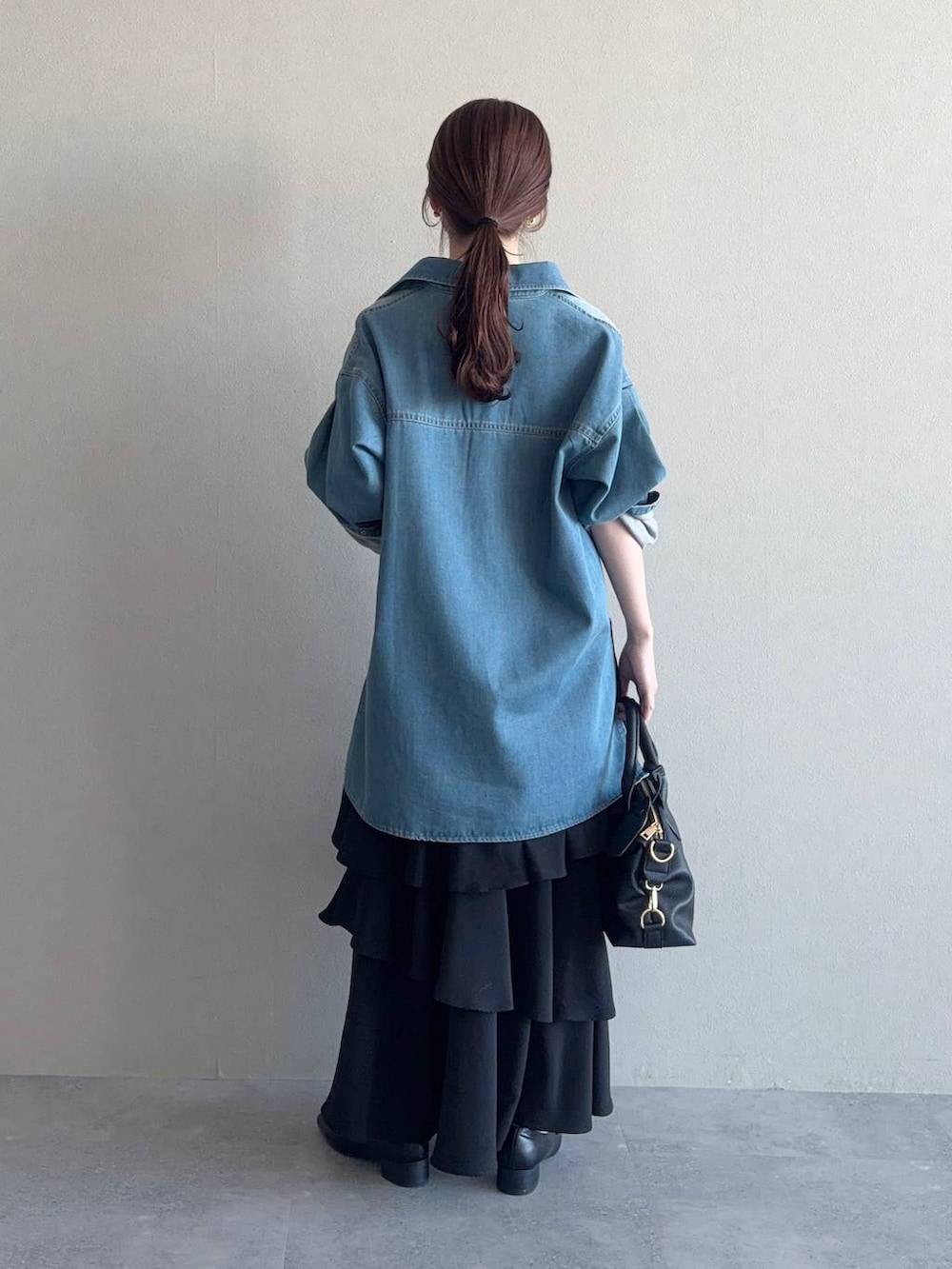 ブラック系のボストンバッグ、ブラック系のローファー、ブラック系のスカートを着用したレディースの冬コーディネートの2枚目の写真