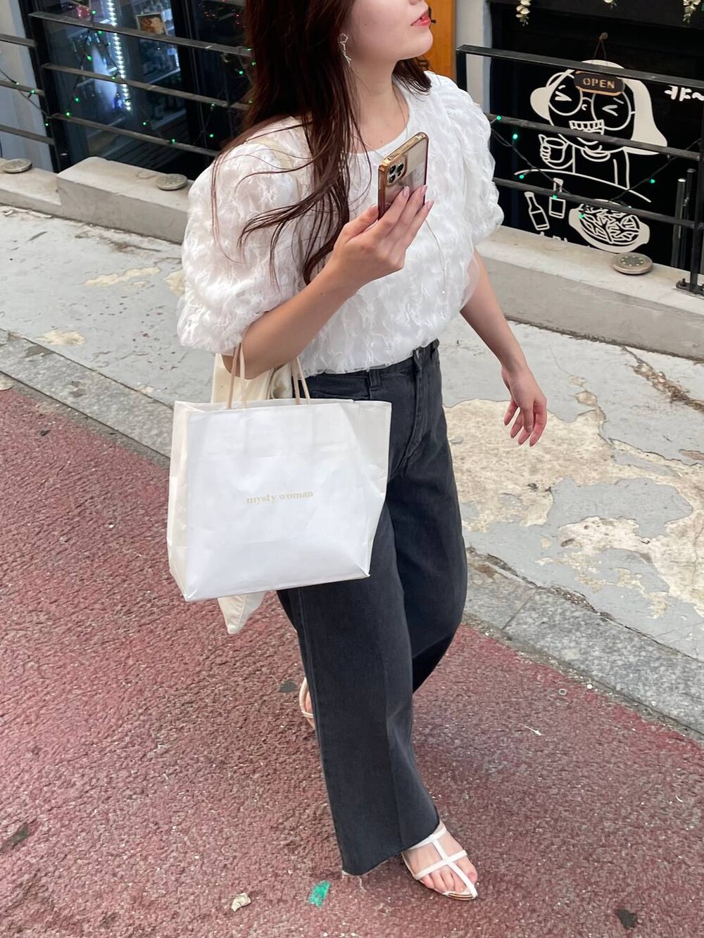 ホワイト系のシャツ/ブラウス、ホワイト系のサンダル、ブラック系のデニムパンツを着用したレディースの夏コーディネートの5枚目の写真