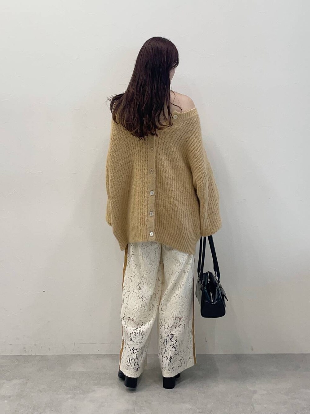 ブラック系のブーツ、ホワイト系のその他パンツ、ブラック系のハンドバッグを着用したレディースの秋コーディネートの2枚目の写真