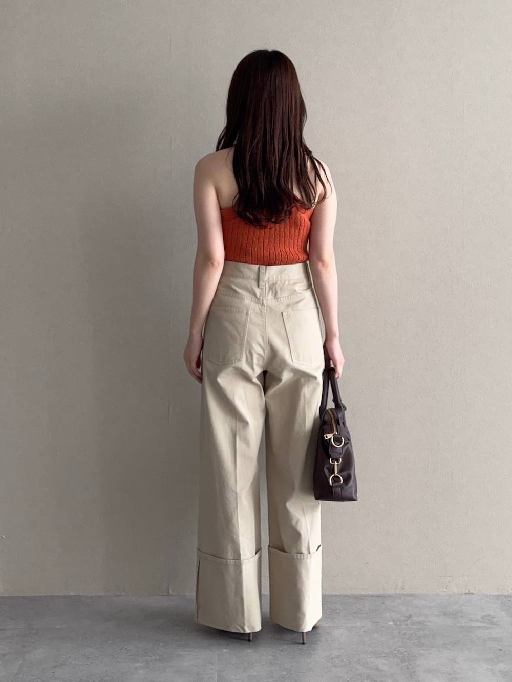 ホワイト系のパーカー、ブラウン系のボストンバッグ、ブラウン系のサンダルを着用したレディースの春コーディネートの5枚目の写真