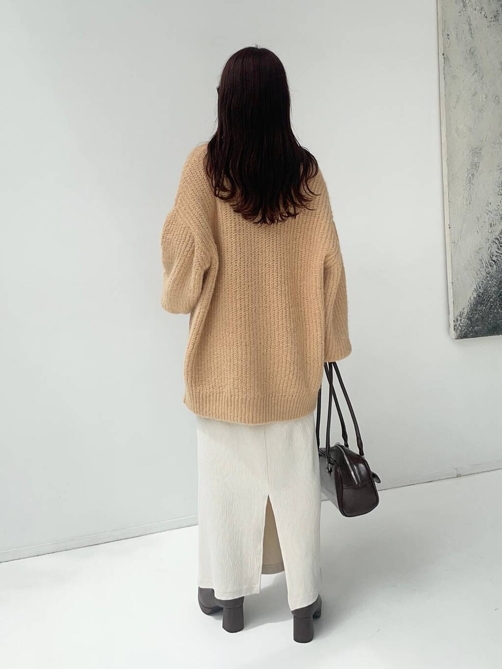 ブラウン系のブーツ、ベージュ系のカーディガン/ボレロ、ベージュ系のTシャツ/カットソーを着用したレディースの秋コーディネートの2枚目の写真