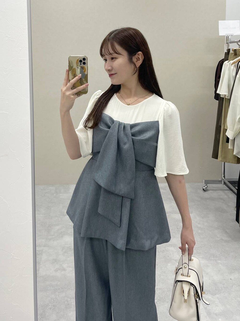 ホワイト系のショルダーバッグ、グレー系のその他パンツ、グレー系のTシャツ/カットソーを着用したレディースの夏コーディネートの2枚目の写真